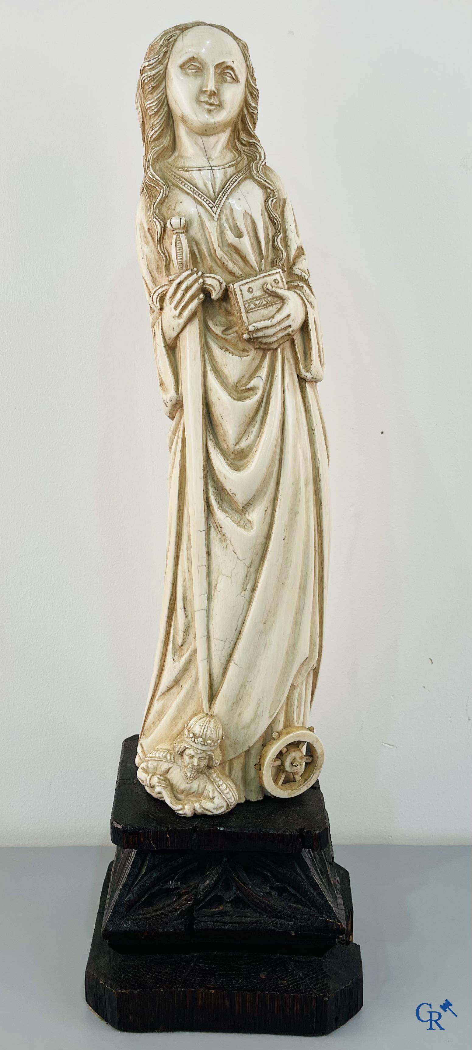 Représentation en ivoire de Sainte Catherine avec l'empereur Maxence sur un piédestal néo-gothique en bois. 