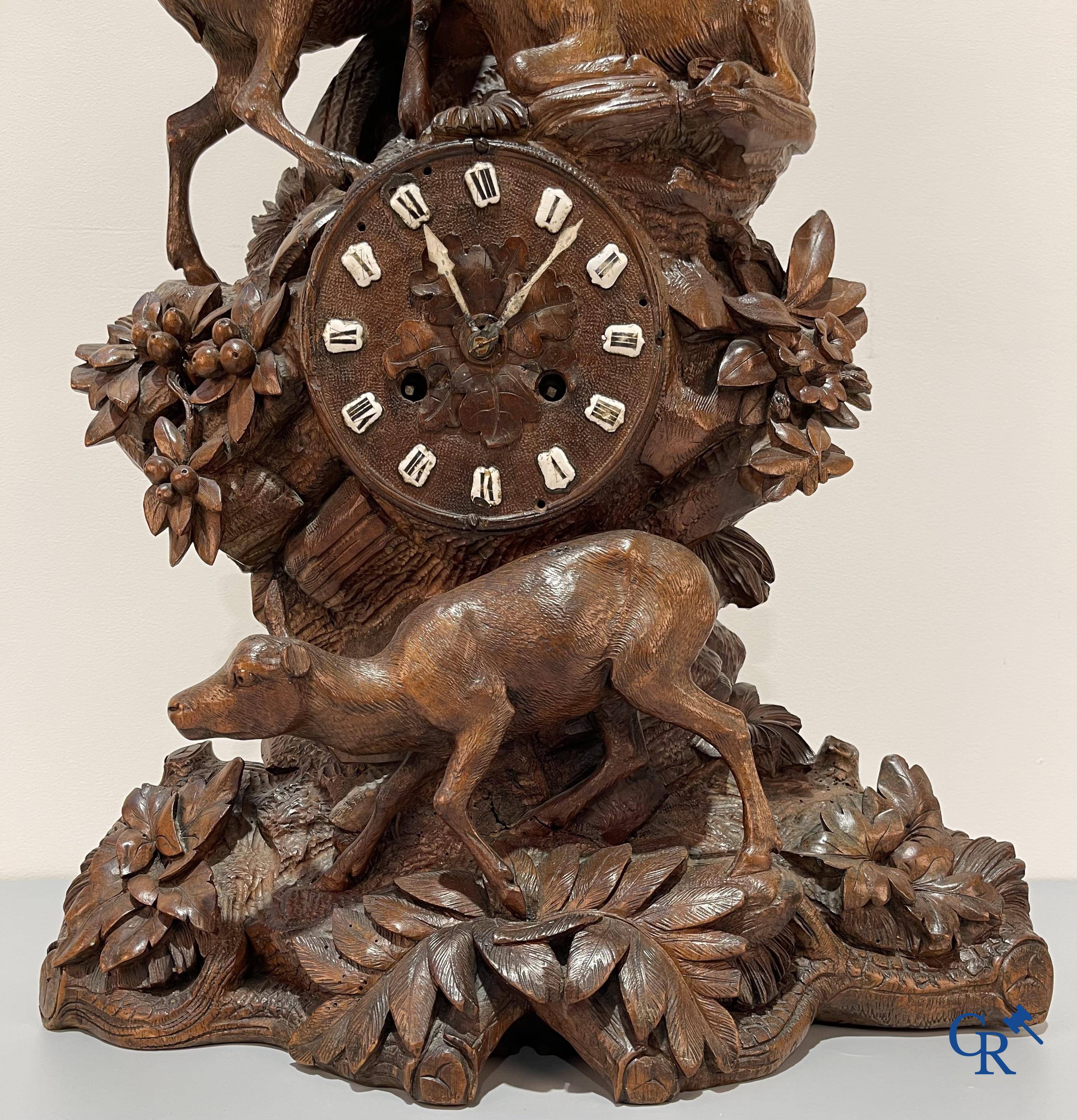 A wood sculpted Black Forest clock with deer in their flora. Germany, late 19th century.