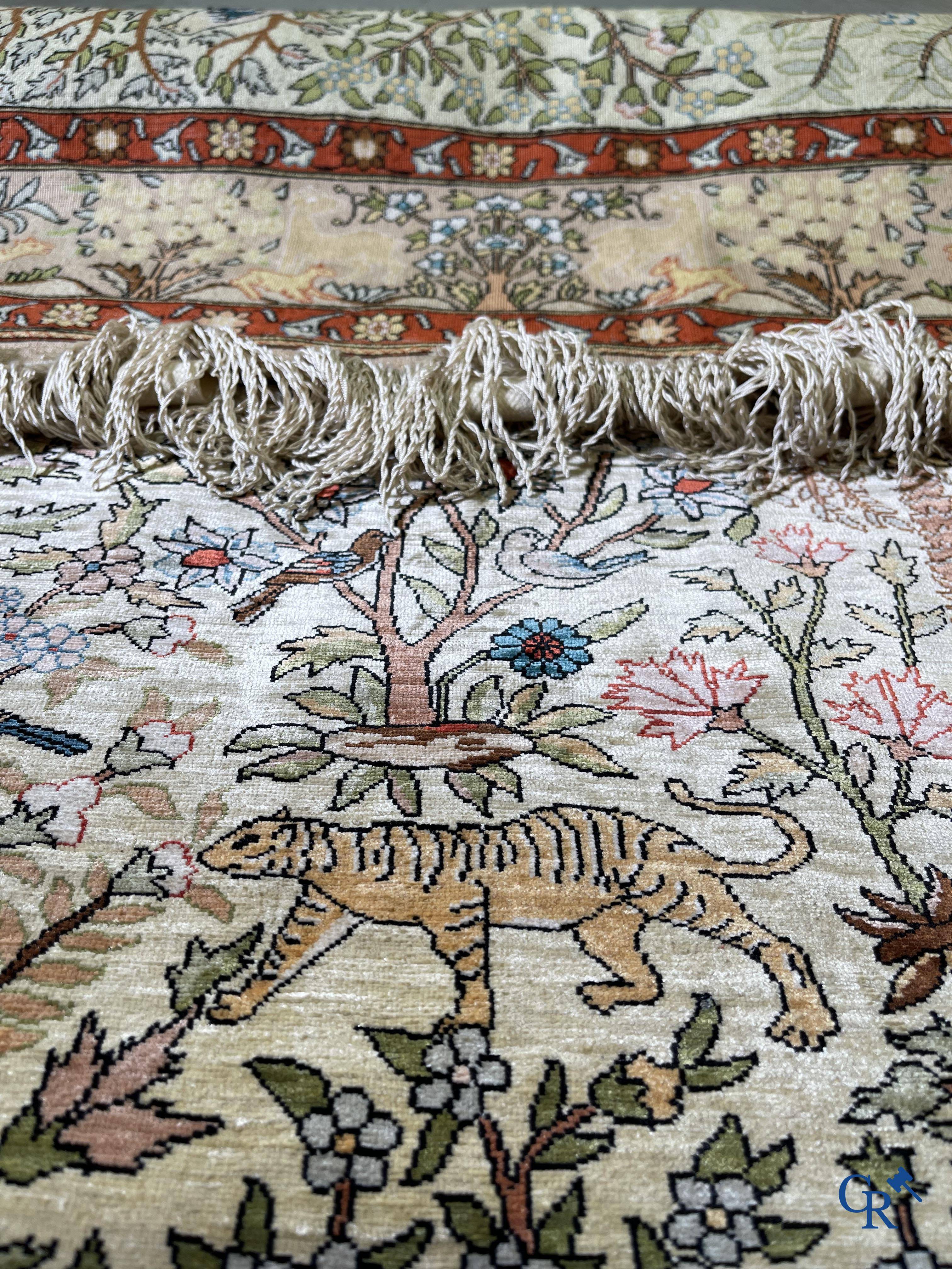 Oriental rugs, a fine hand-knotted silk tapestry with animals in a forest. Signed.