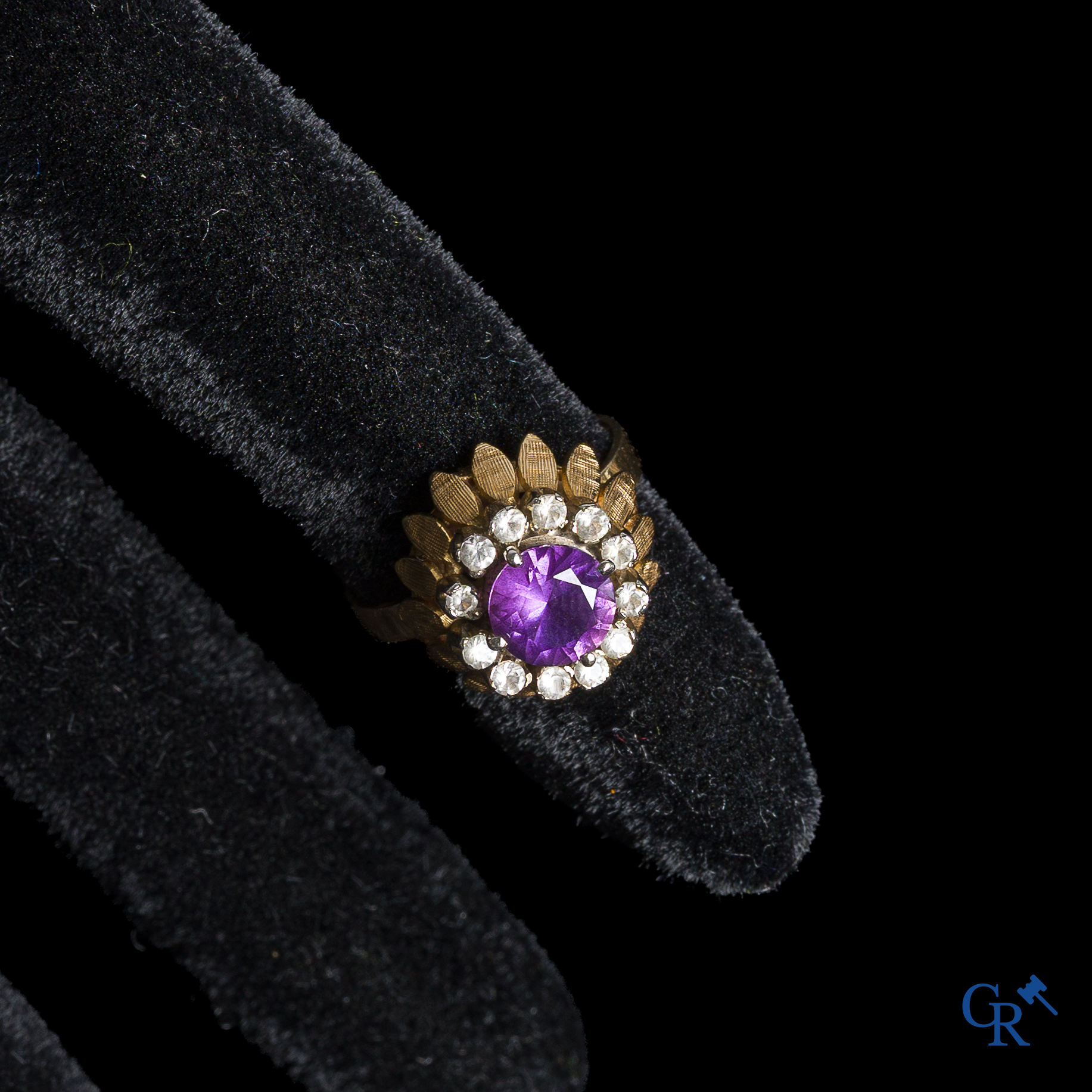 Bijoux. Bague en or 750°/00 avec une améthyste centrale entourée de diamants taillés.