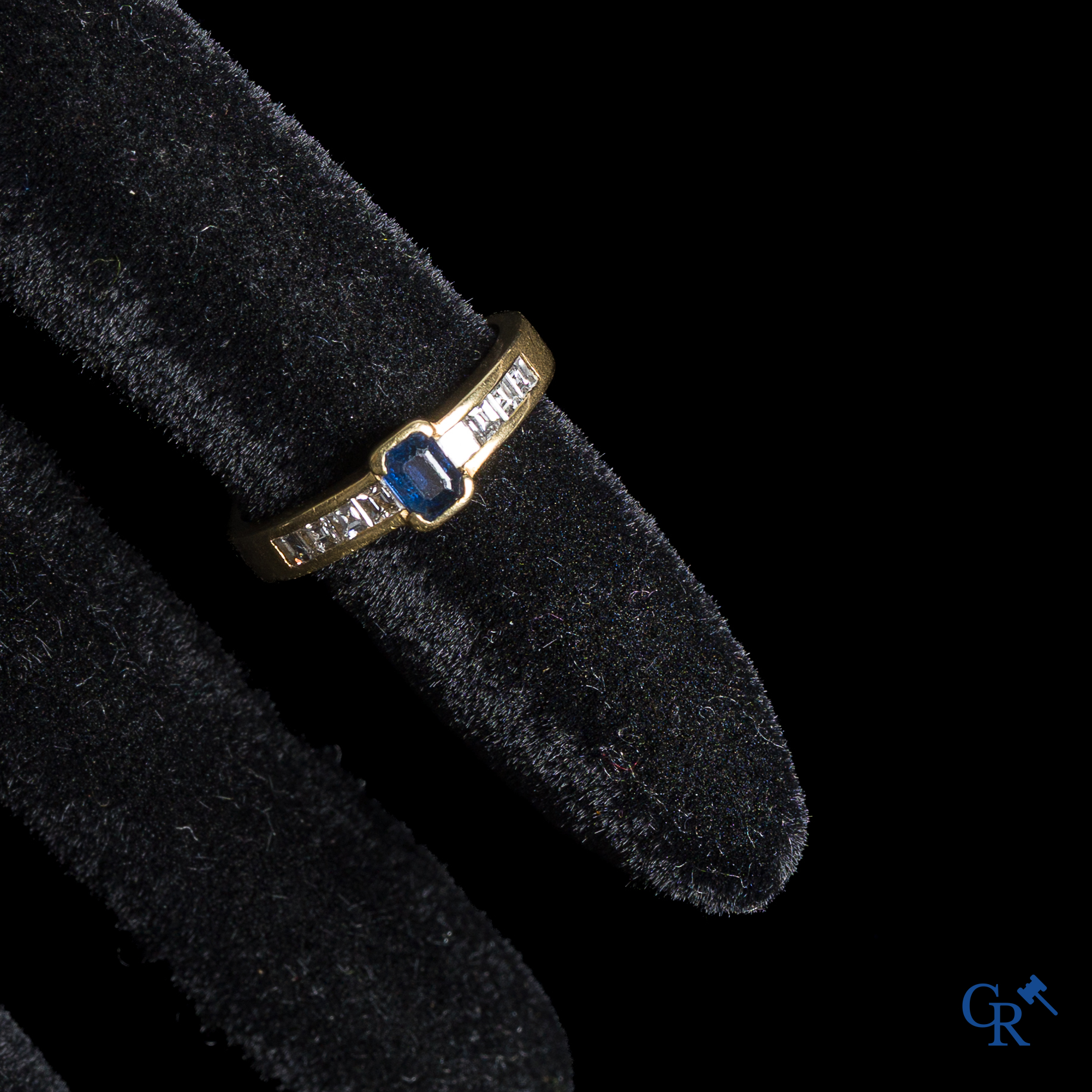 Bijoux. Bague en or 750°/00 avec un saphir bleu et des diamants.