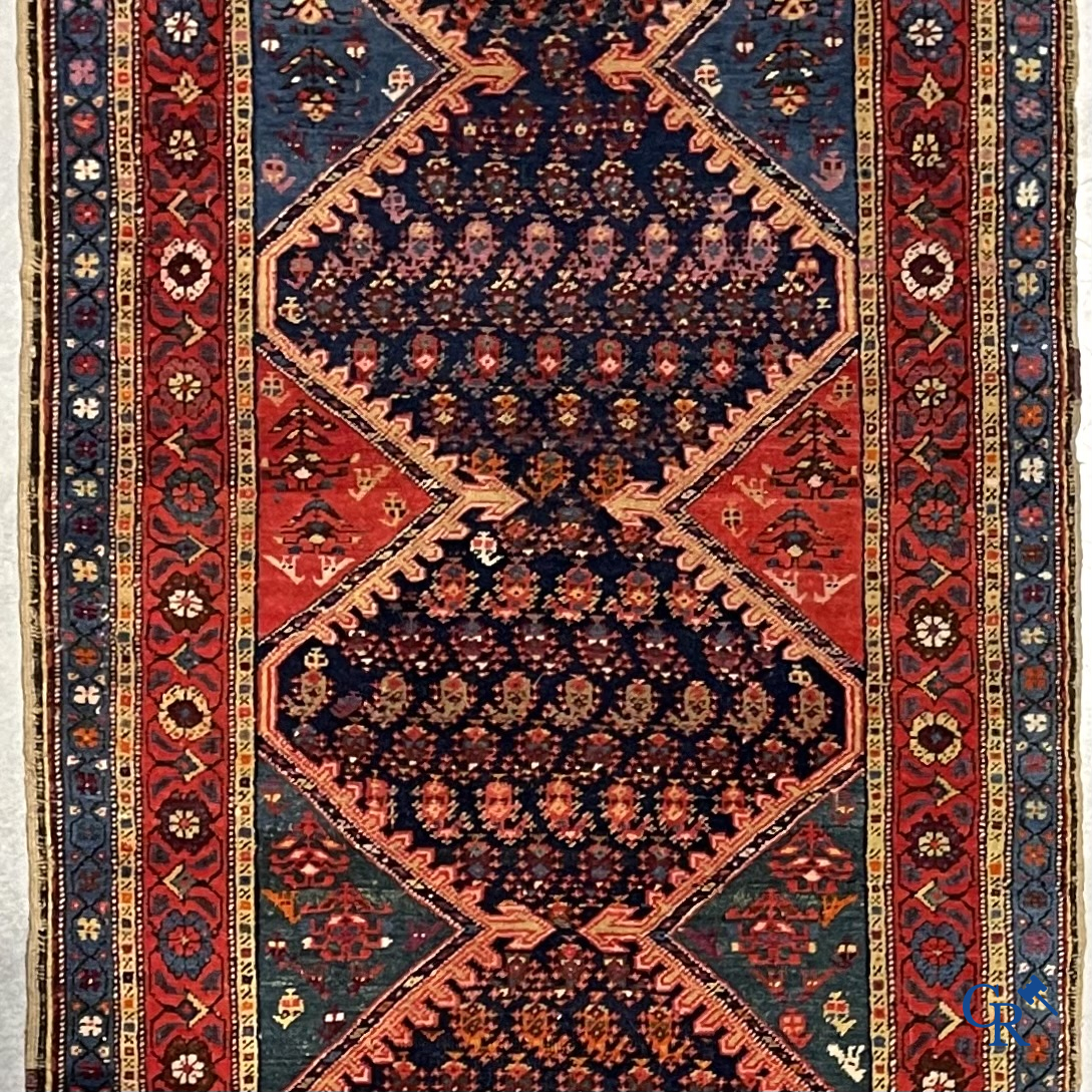 Oosterse tapijten. Een grote handgeknoopte antieke loper met geometrische motieven. 19e eeuw.