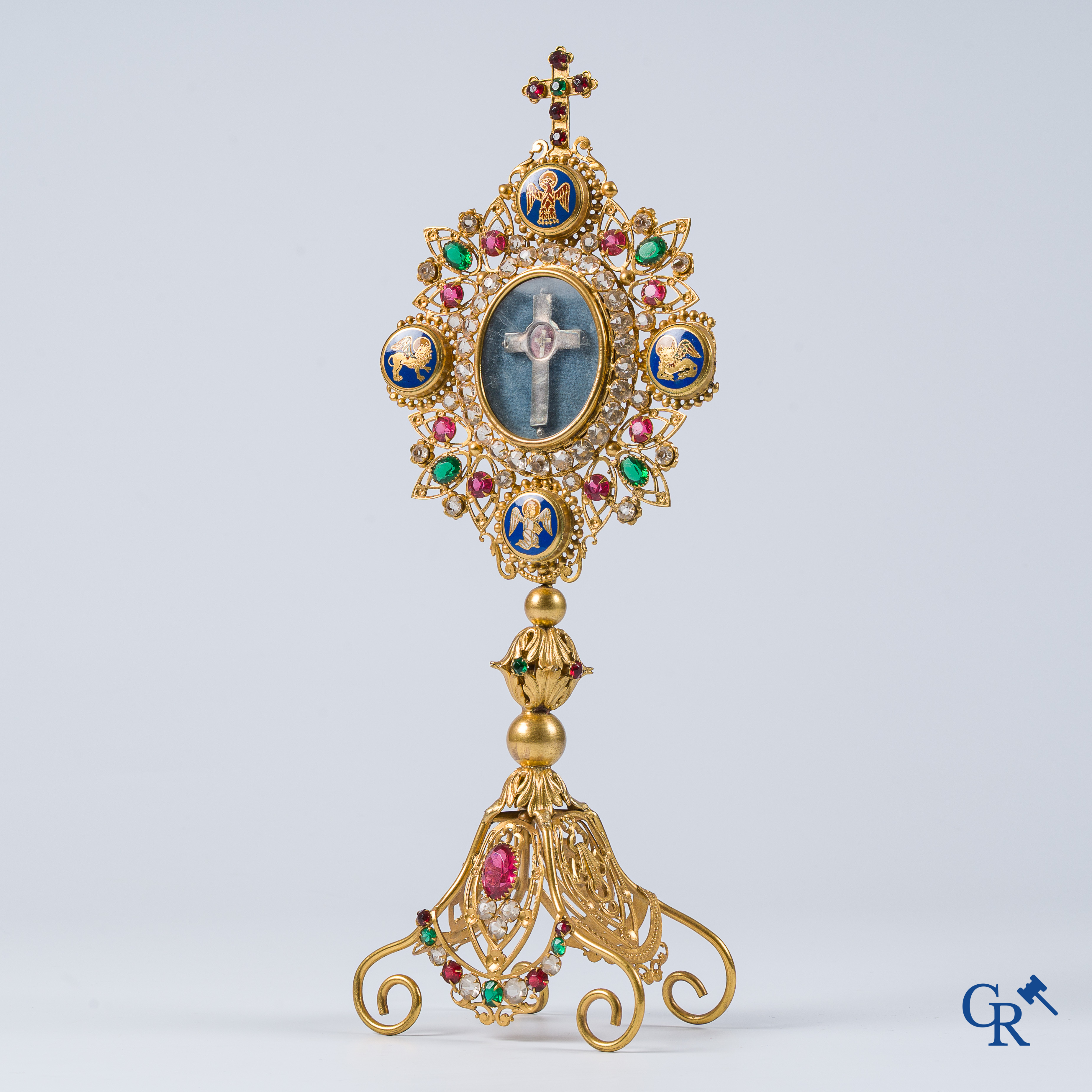 Religieuze objecten. Reliekhouder in messing en Champlevé emaille met een reliek ingewerkt in een zilver kruis.