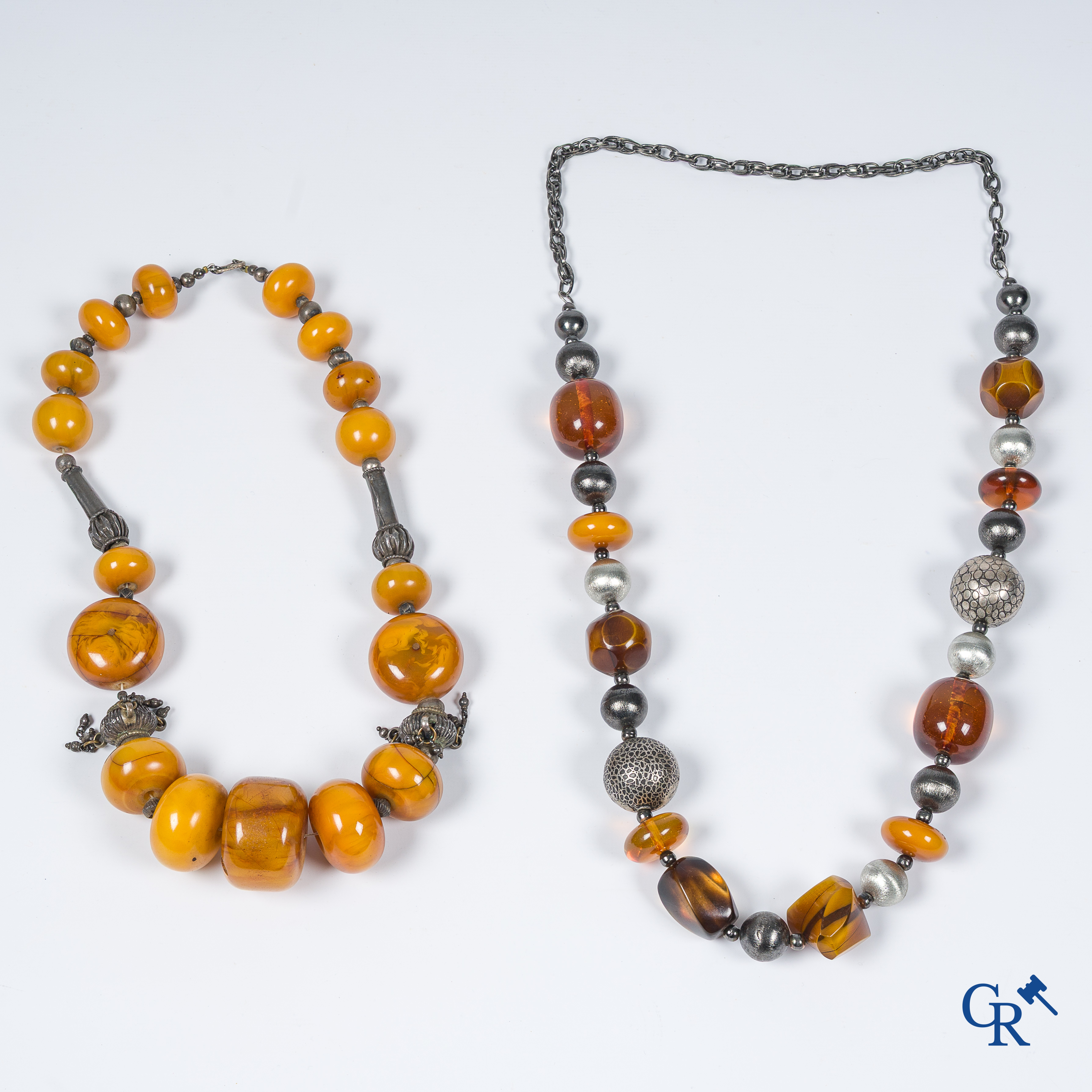 Grand lot avec des bijoux fantaisie, principalement en argent, y compris des colliers avec des éléments de couleur ambre.