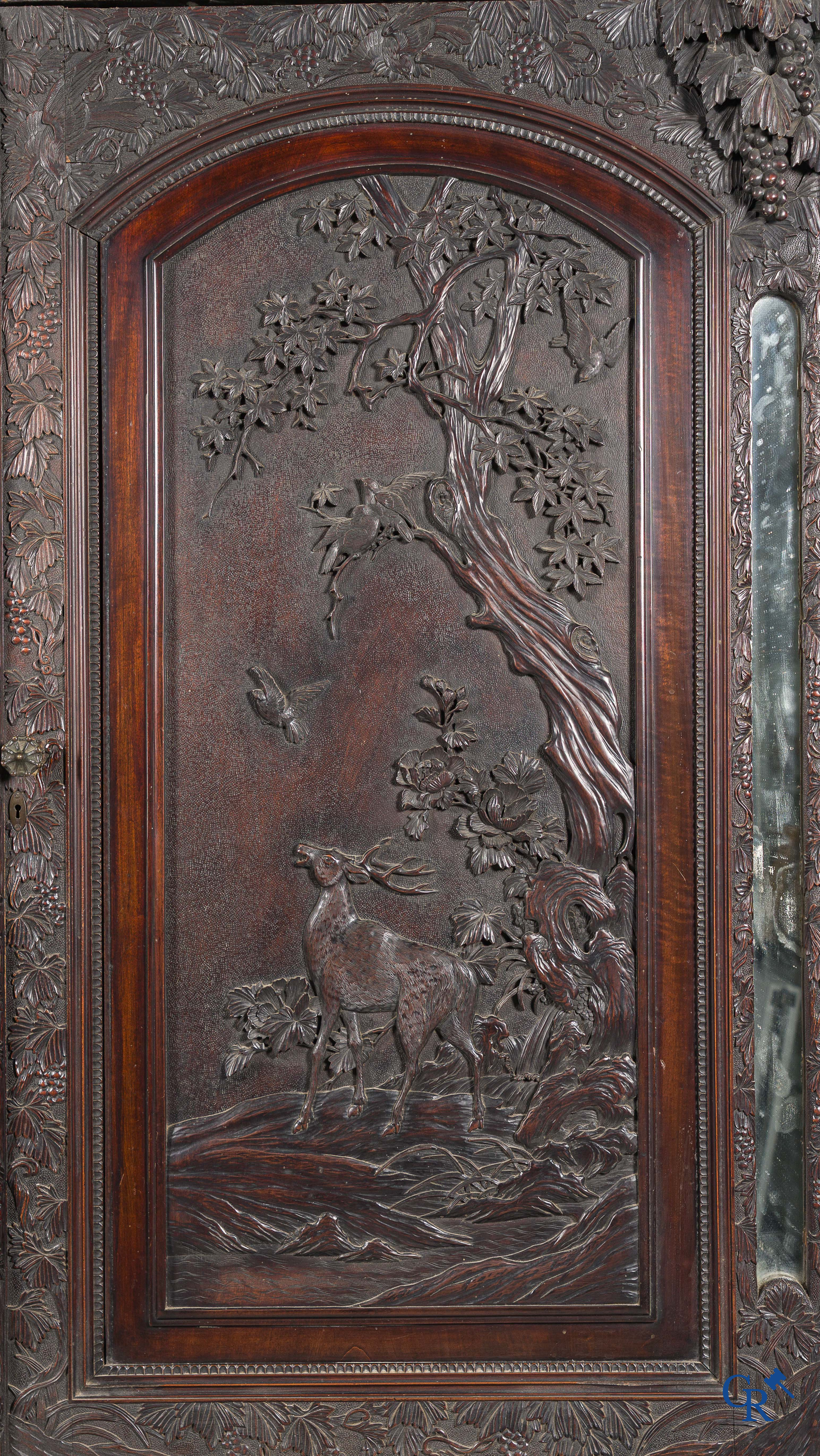 Art Asiatique. Exceptionnel et impressionnant meuble avec des panneaux chinois finement sculptés. XIXe siècle.