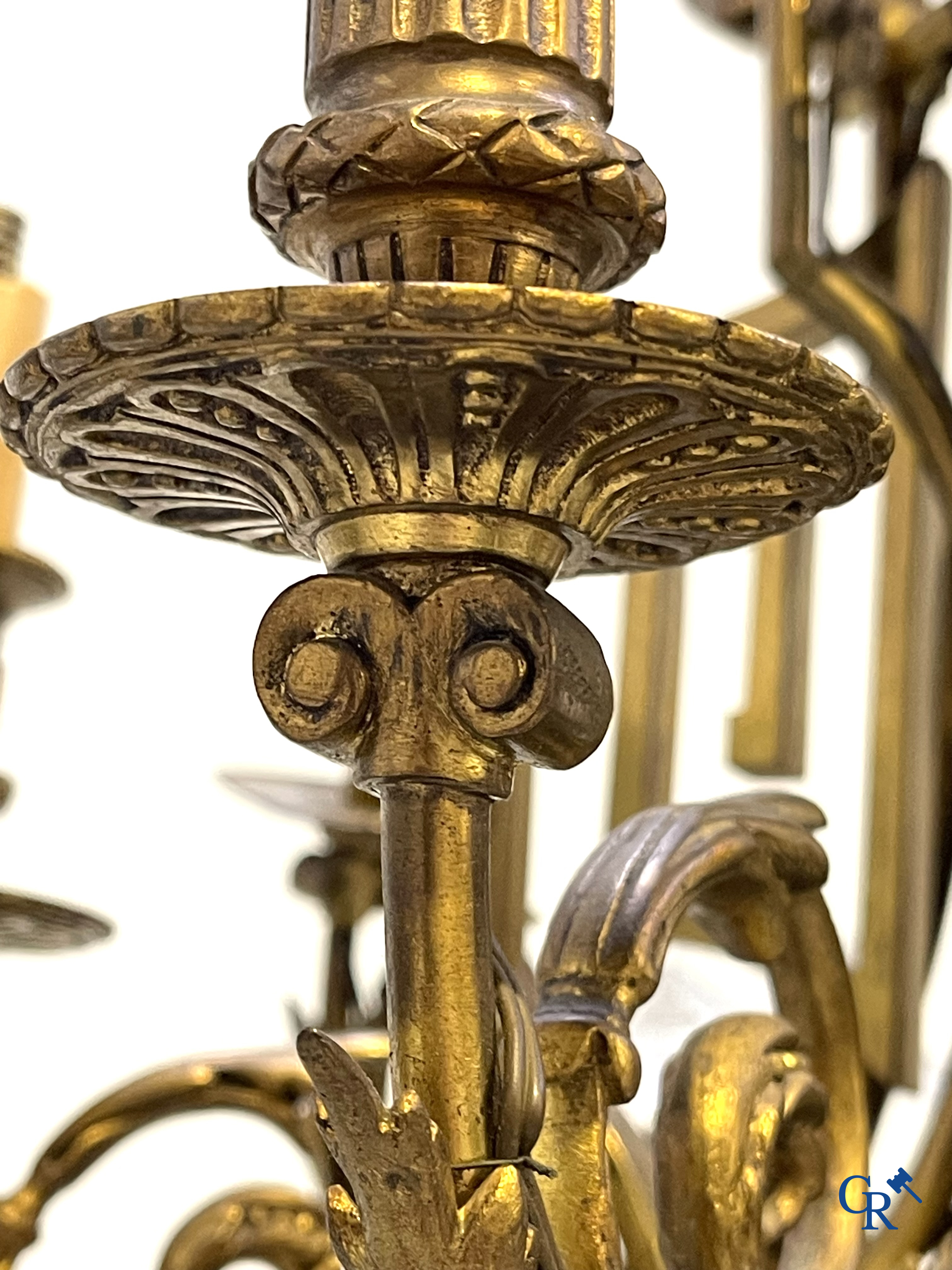 A lot of an imposing chandelier with 12 light points, a lamp belge with bronze frame and a fireplace piece.