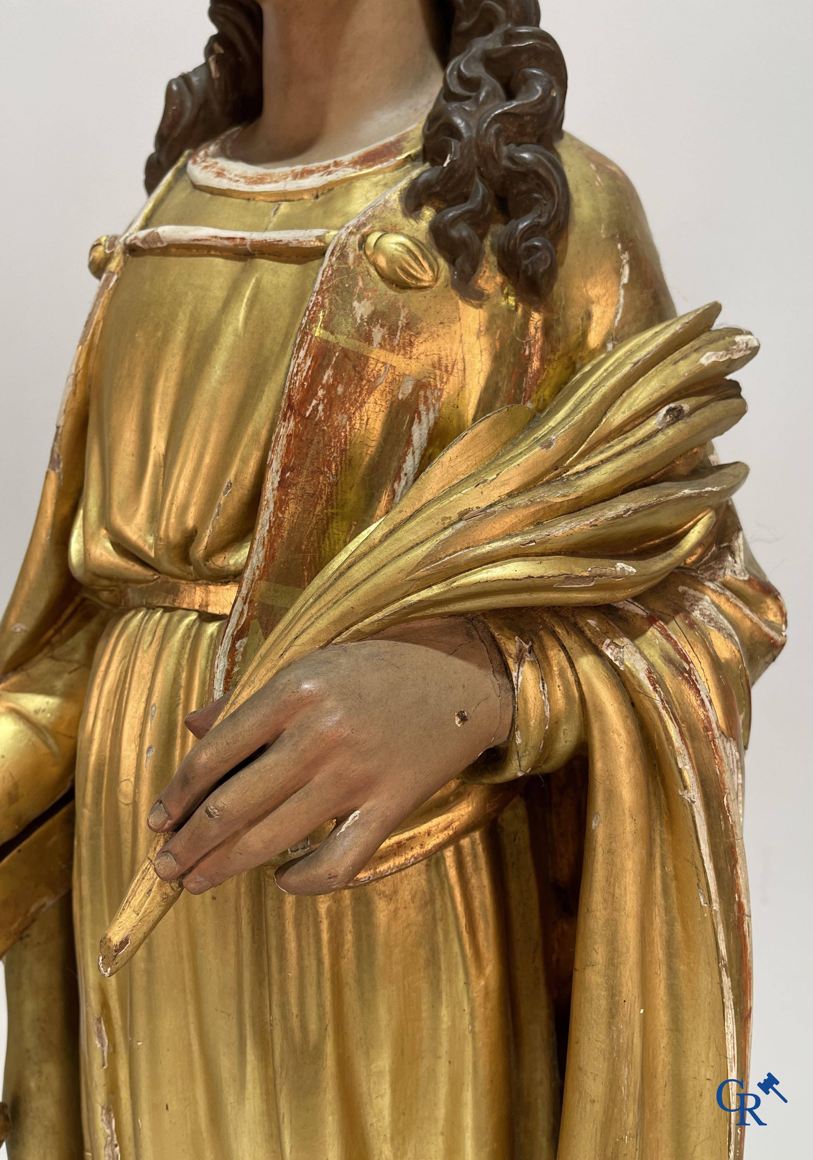 A large gilded and polychrome wooden statue of Saint Catherine of Alexandria.
