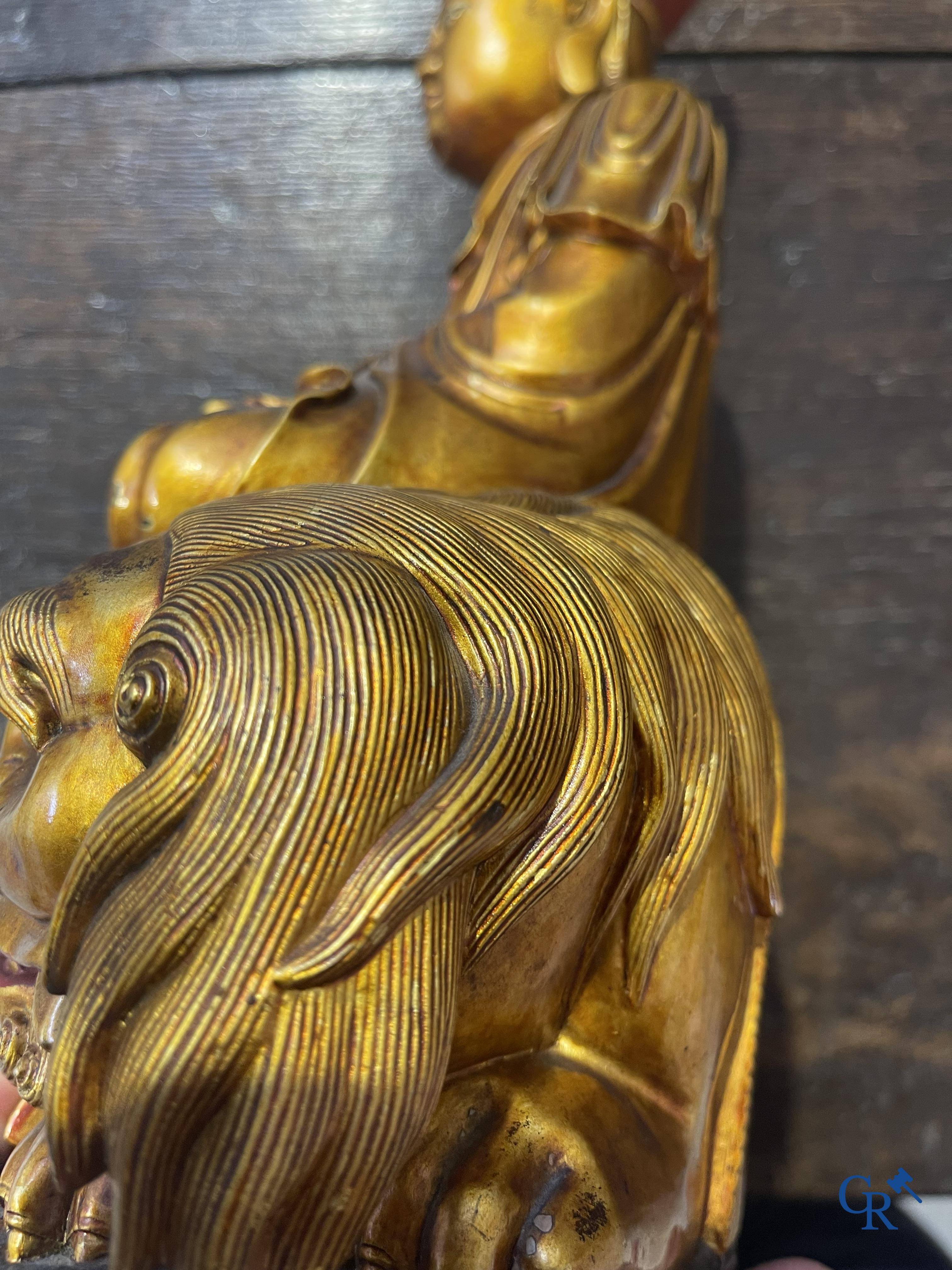 Asian Art: A Chinese sculpture of Vaishravana on a Buddhist lion in lacquered and gilded wood. 19th century.