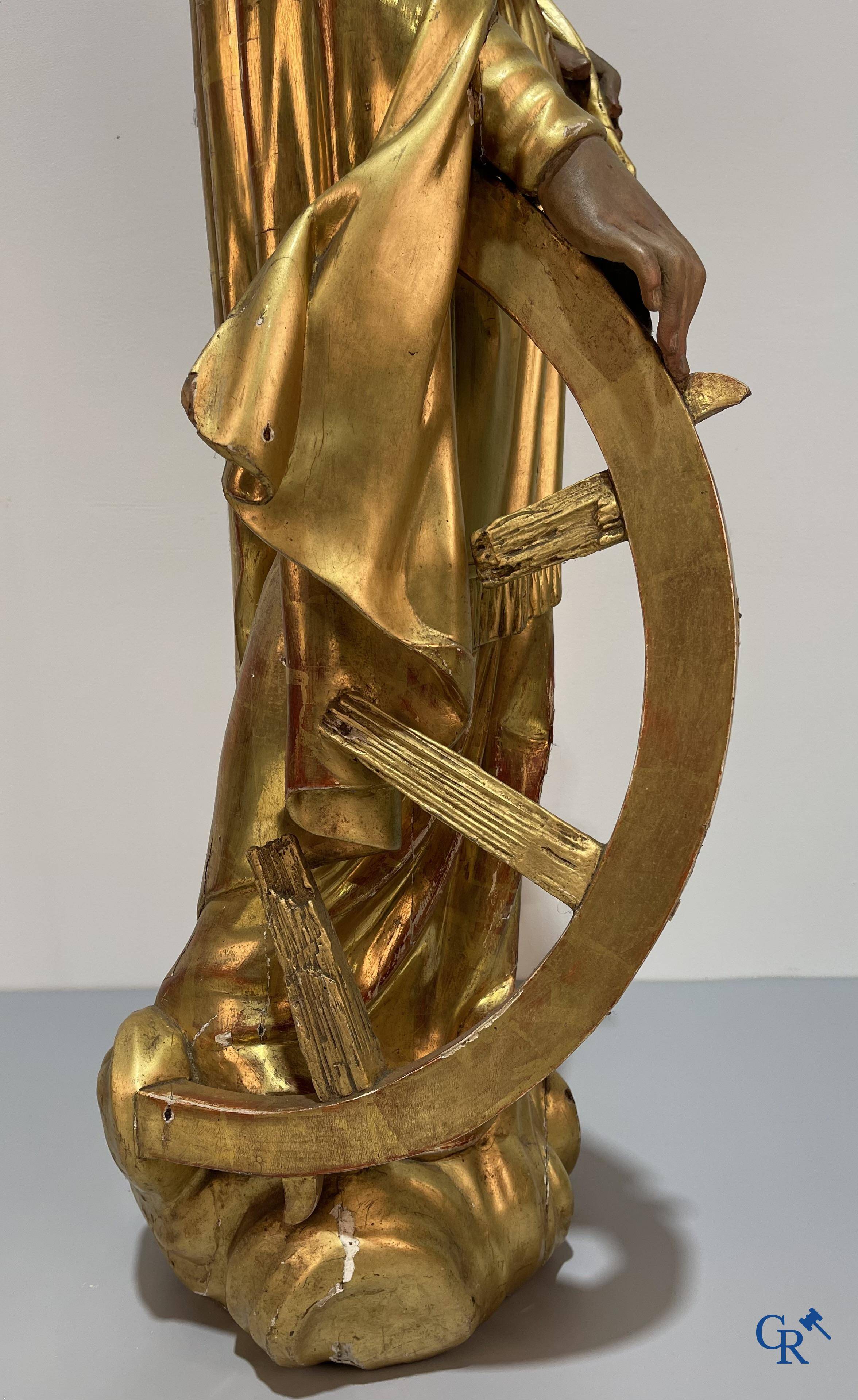 A large gilded and polychrome wooden statue of Saint Catherine of Alexandria.