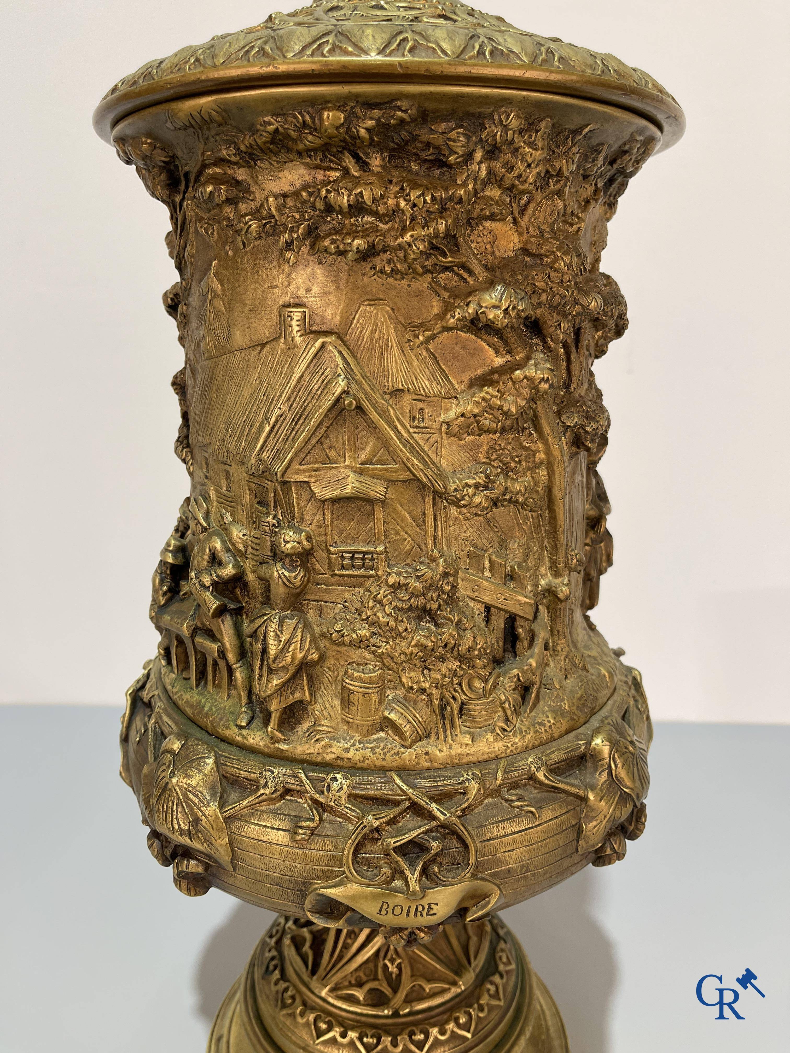 Un imposant pot à tabac en bronze finement travaillée avec les inscriptions "aimer, danser, fumer, boire".<br />
19ème siècle.