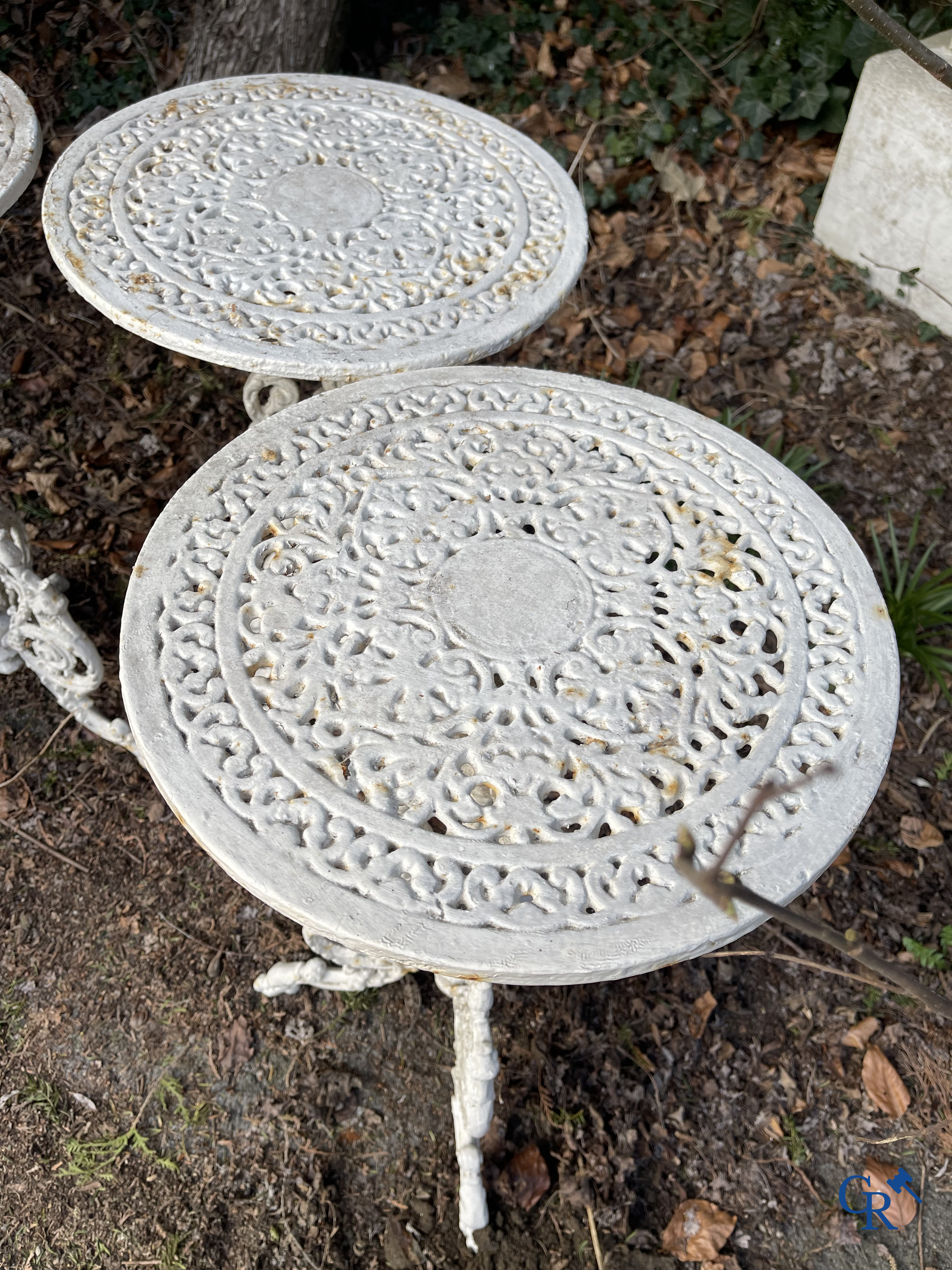 Een reeks van 6 tuinstoelen en 3 geuridons in gietijzer, een metalen tuinbankje bijgevoegd.