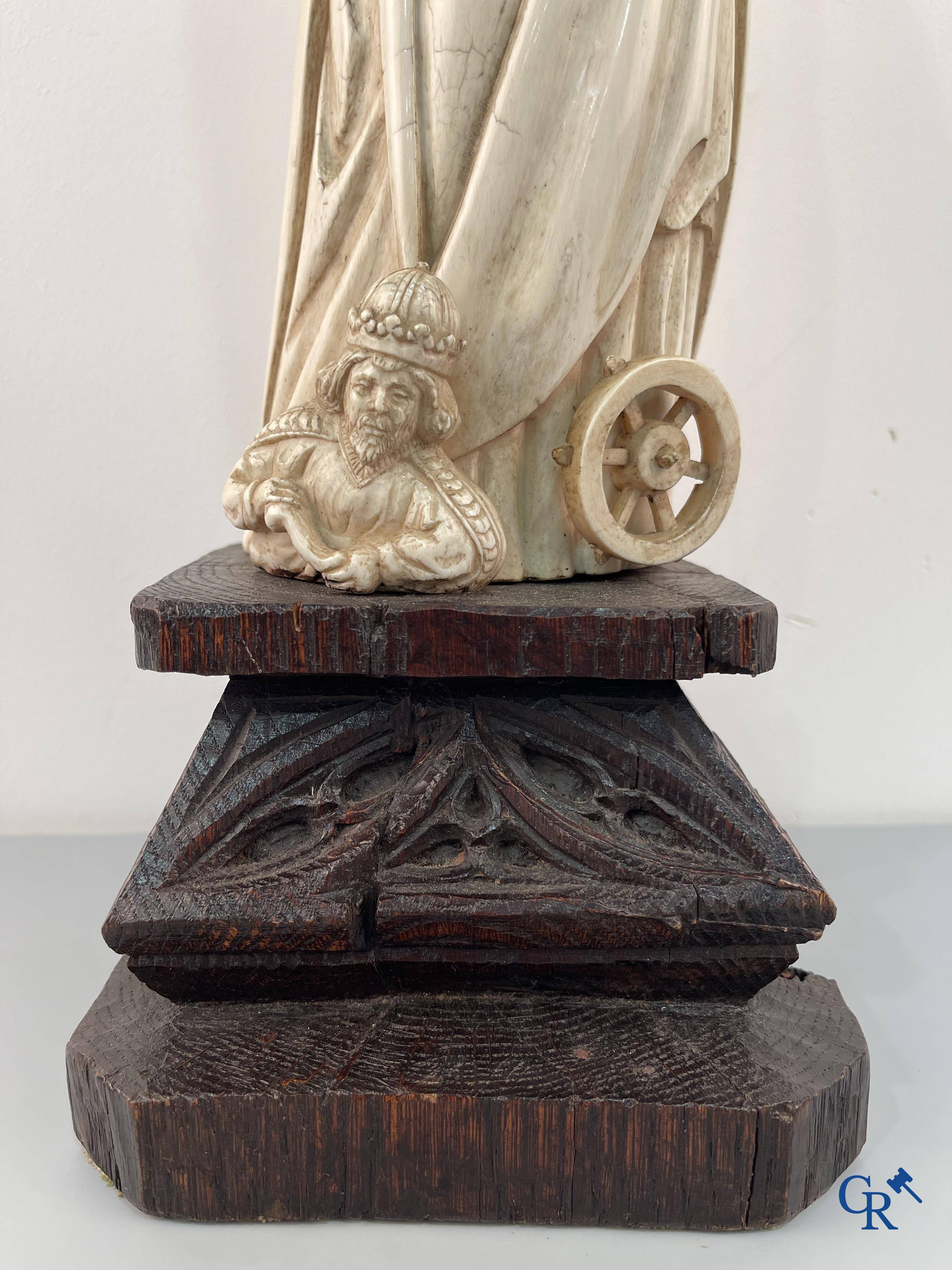 Représentation en ivoire de Sainte Catherine avec l'empereur Maxence sur un piédestal néo-gothique en bois. 