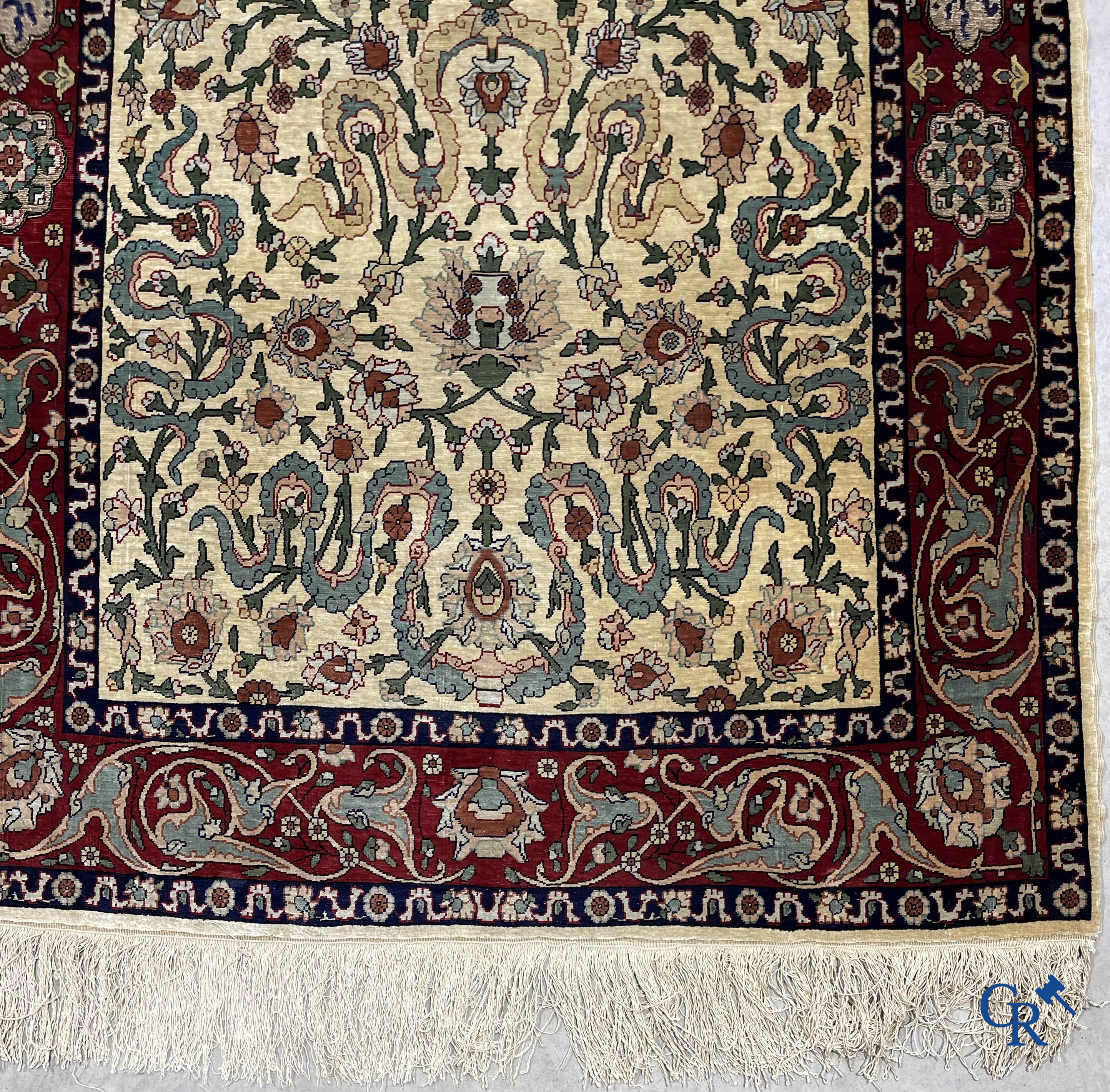 Oosterse tapijten. Een zijden gesigneerd tapijt op donkerrode achtergrond. Inscripties en bewerkt met gouddraad.