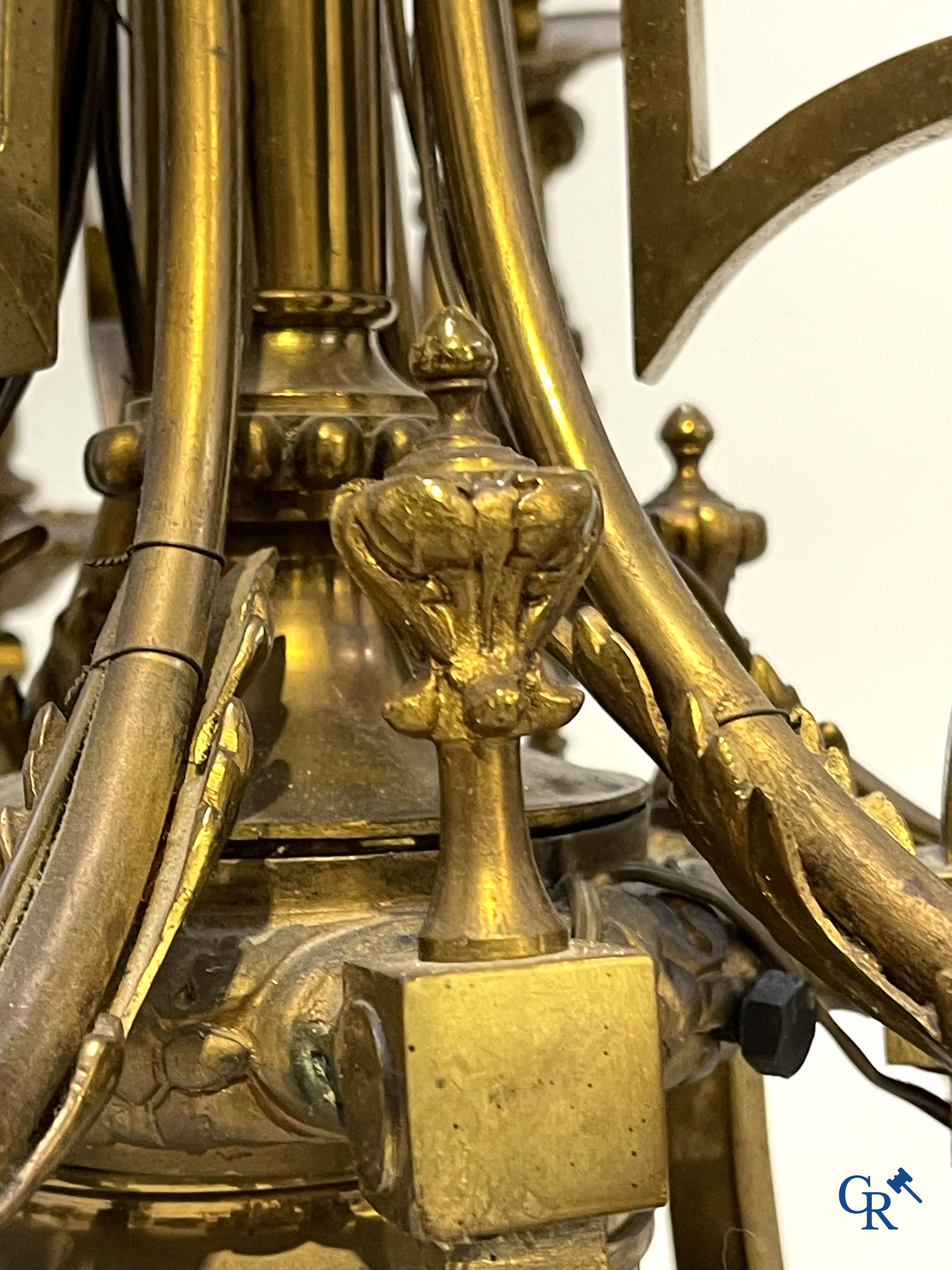 A lot of an imposing chandelier with 12 light points, a lamp belge with bronze frame and a fireplace piece.