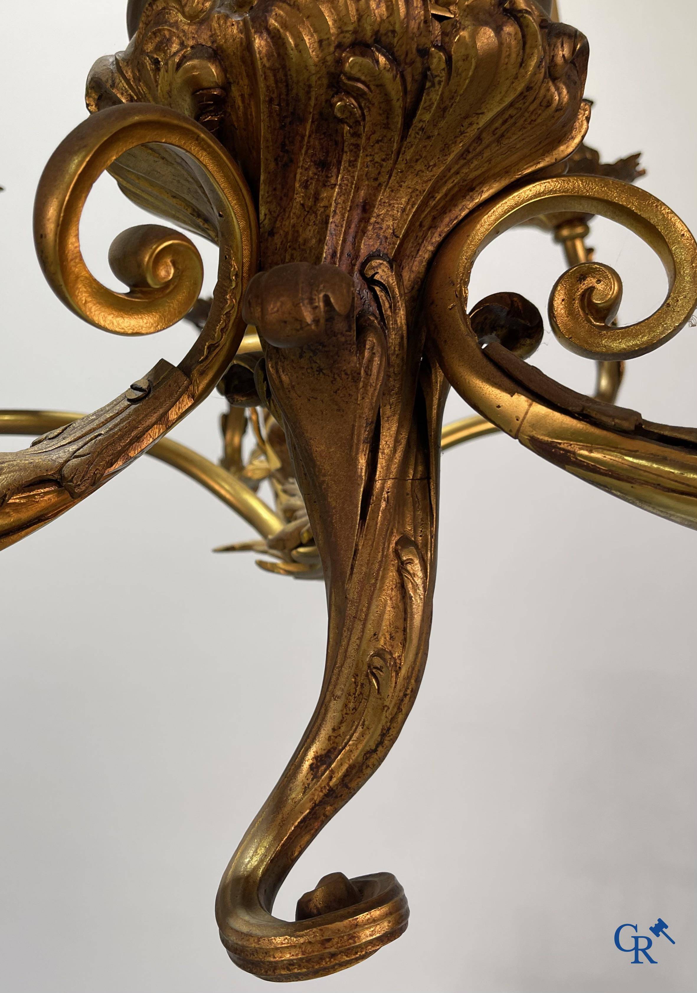 A bronze chandelier with putti and 9 light points in LXV style. Circa 1920.