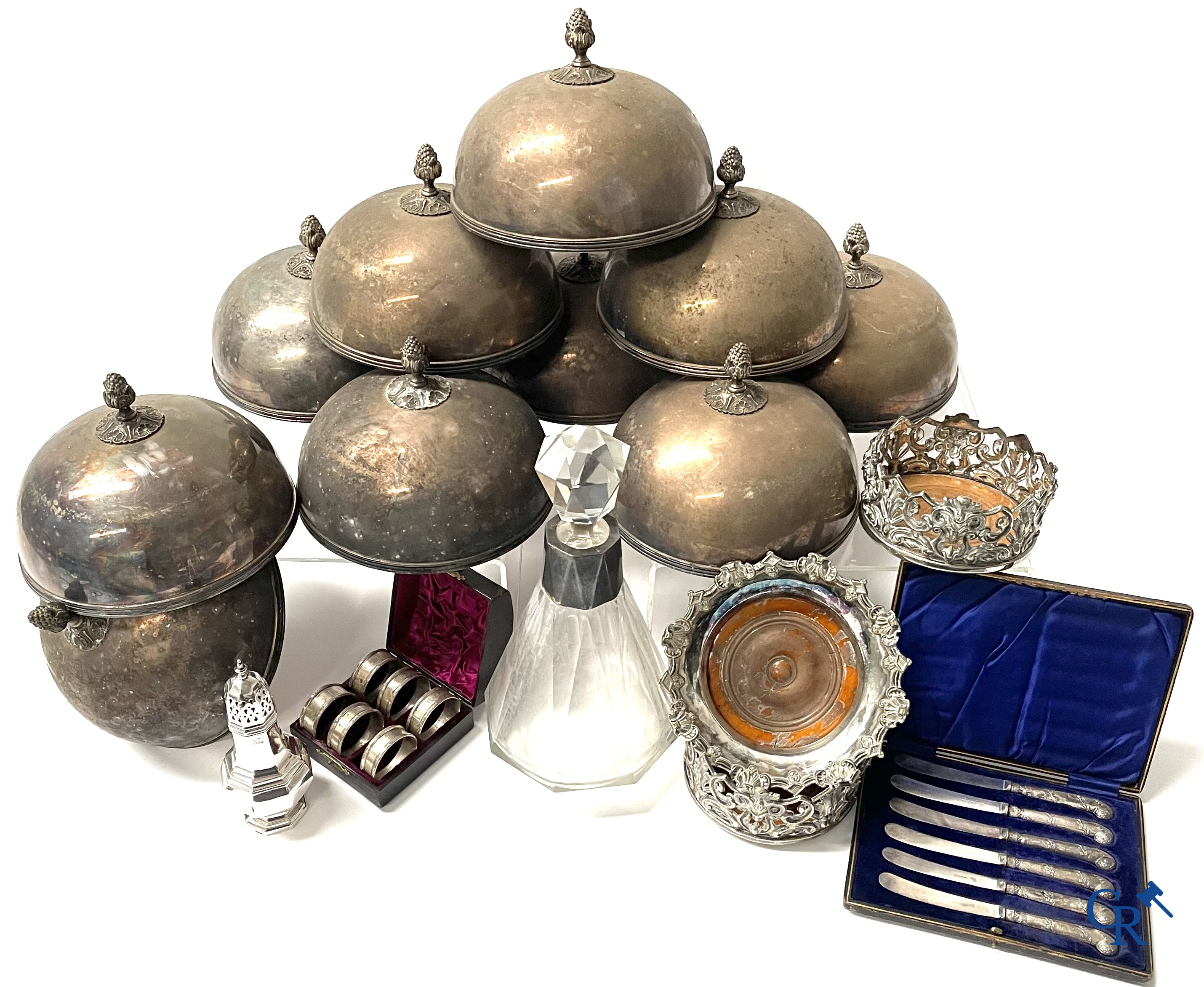 Een reeks van 10 verzilverde bordklokken, een karaf met zilver montuur, zilveren servietringen, een strooibus, enz.