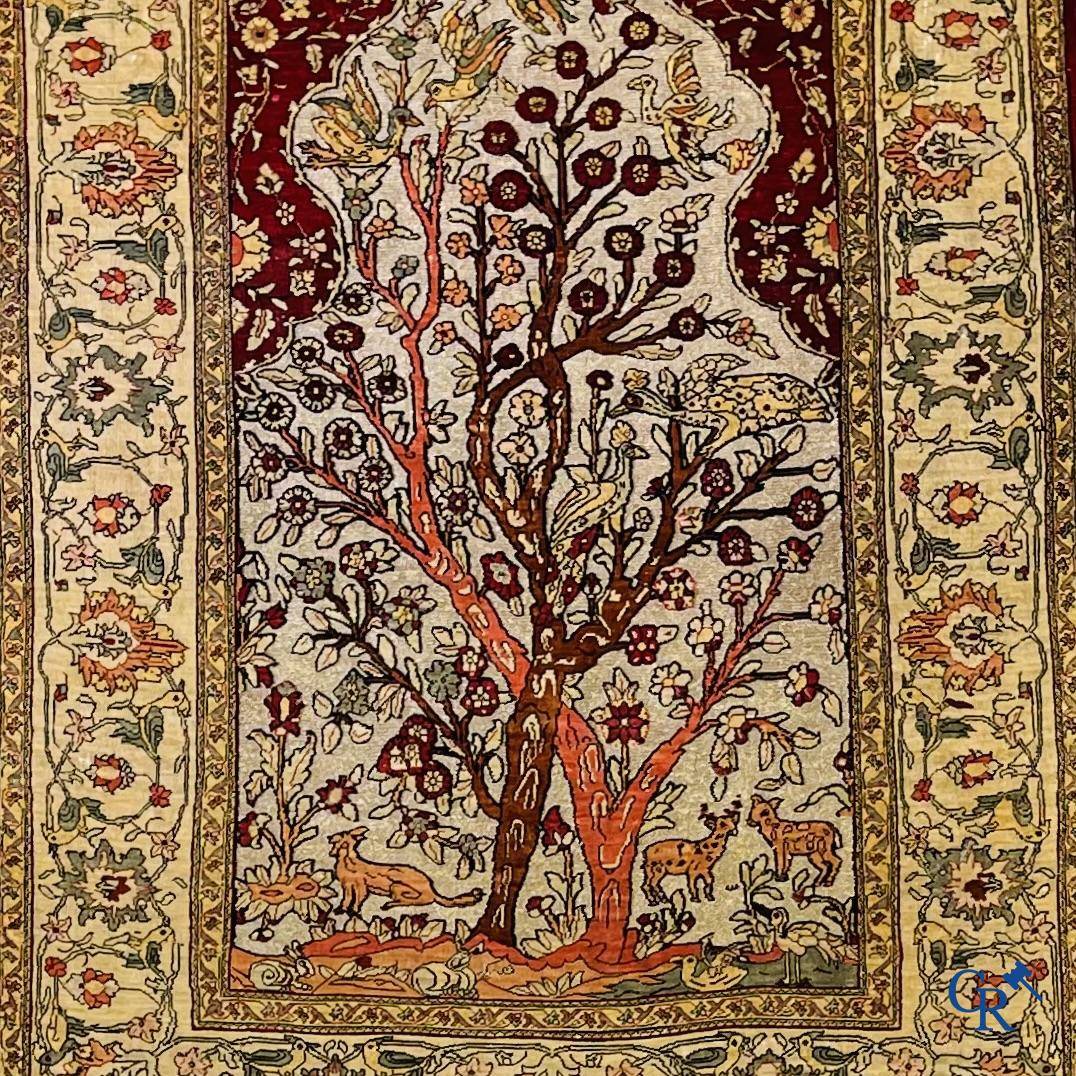Oriental carpets, a hand-knotted carpet in silk with forest animals in a floral decor on a background in gold thread.