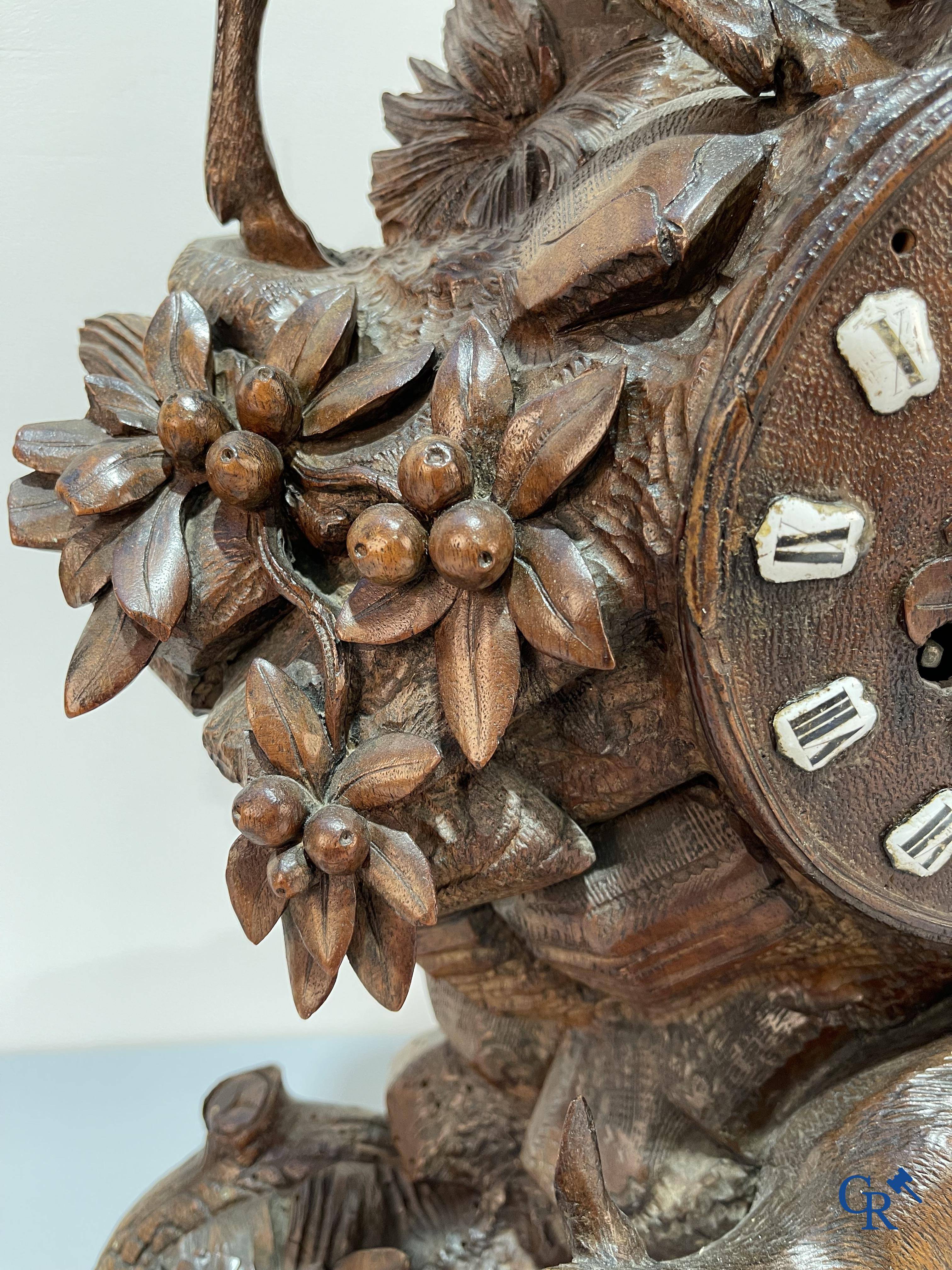 A wood sculpted Black Forest clock with deer in their flora. Germany, late 19th century.