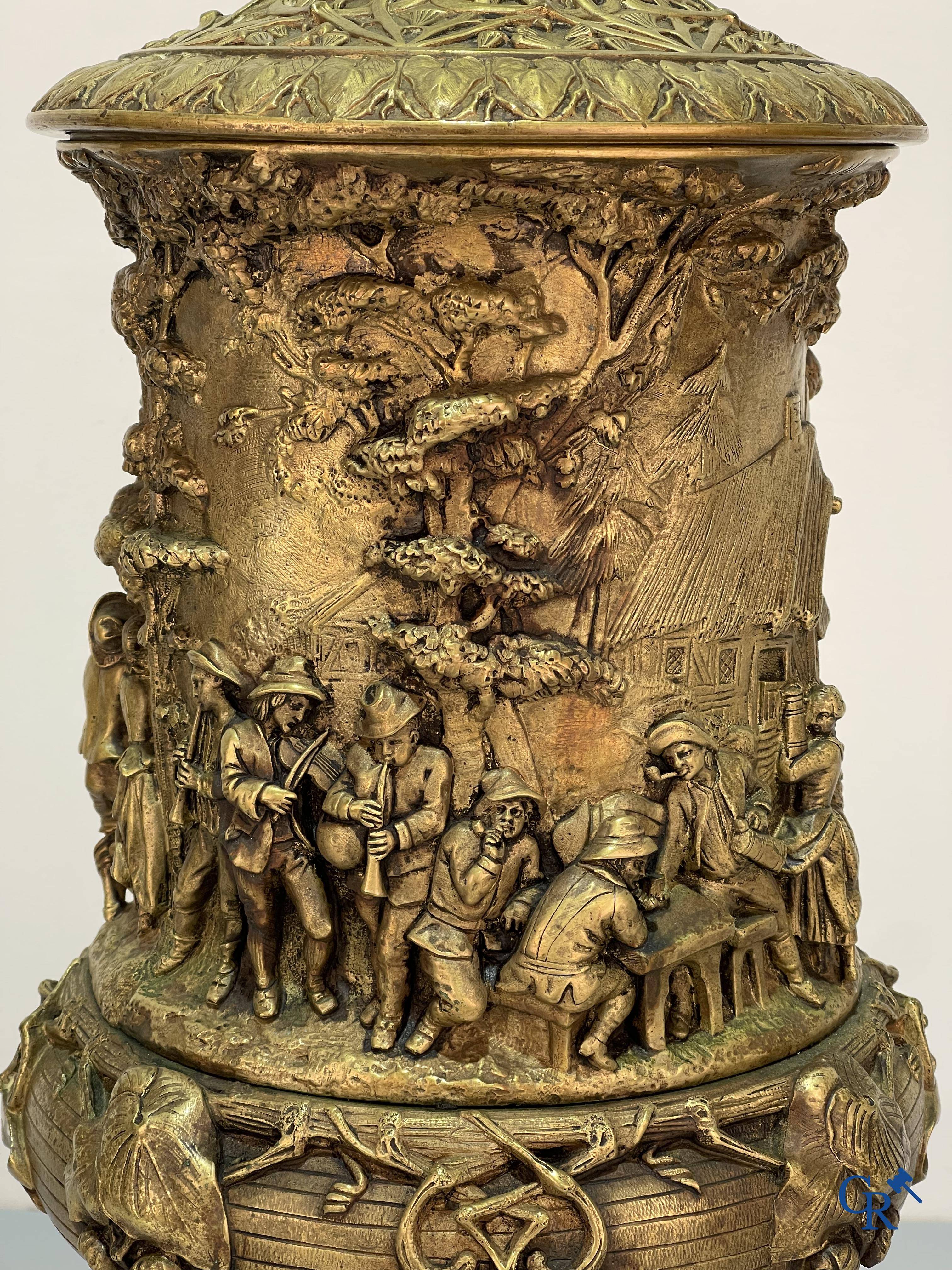 Un imposant pot à tabac en bronze finement travaillée avec les inscriptions "aimer, danser, fumer, boire".<br />
19ème siècle.