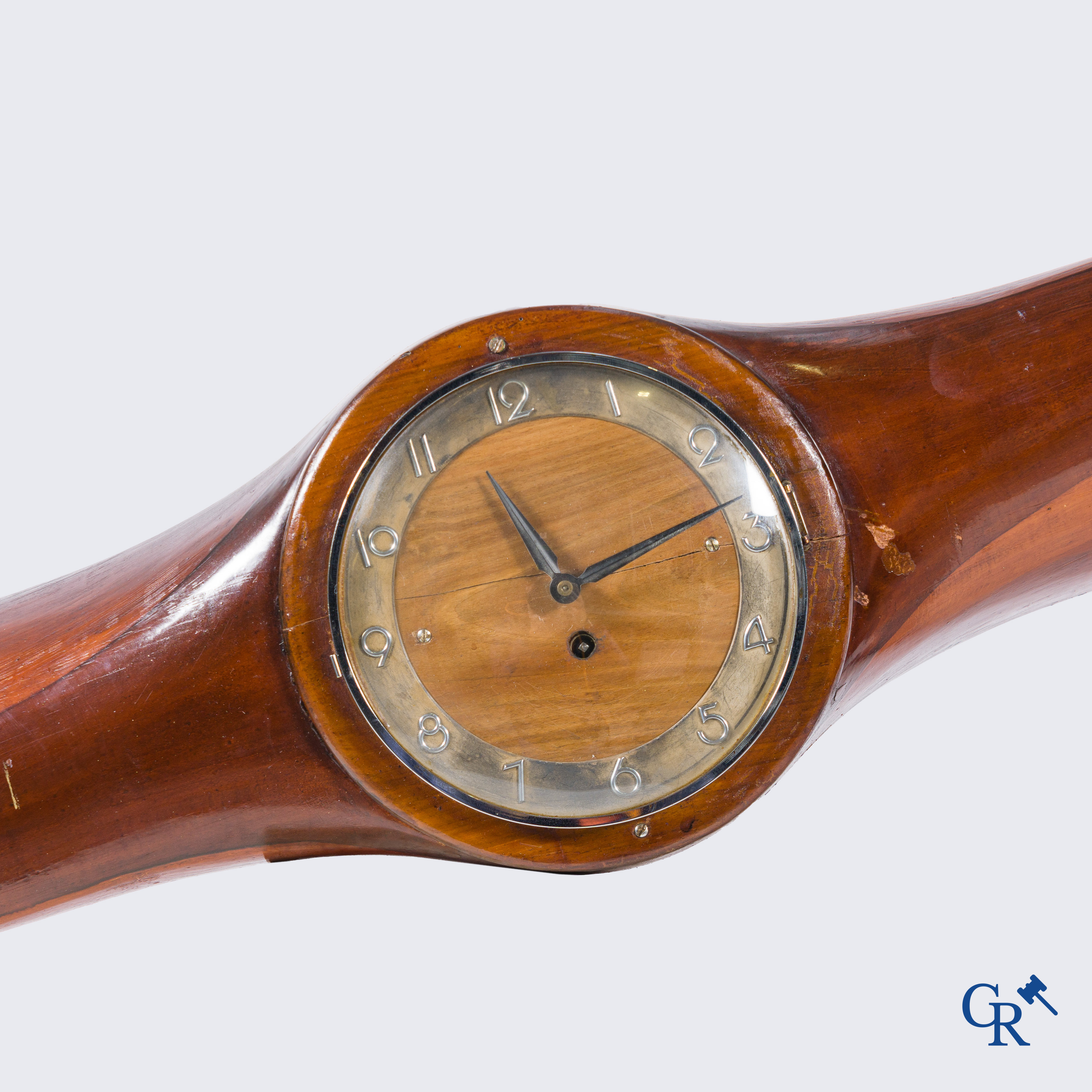 Une grande hélice en bois avec des raccords en cuivre et un mouvement d'horloge rapporté.