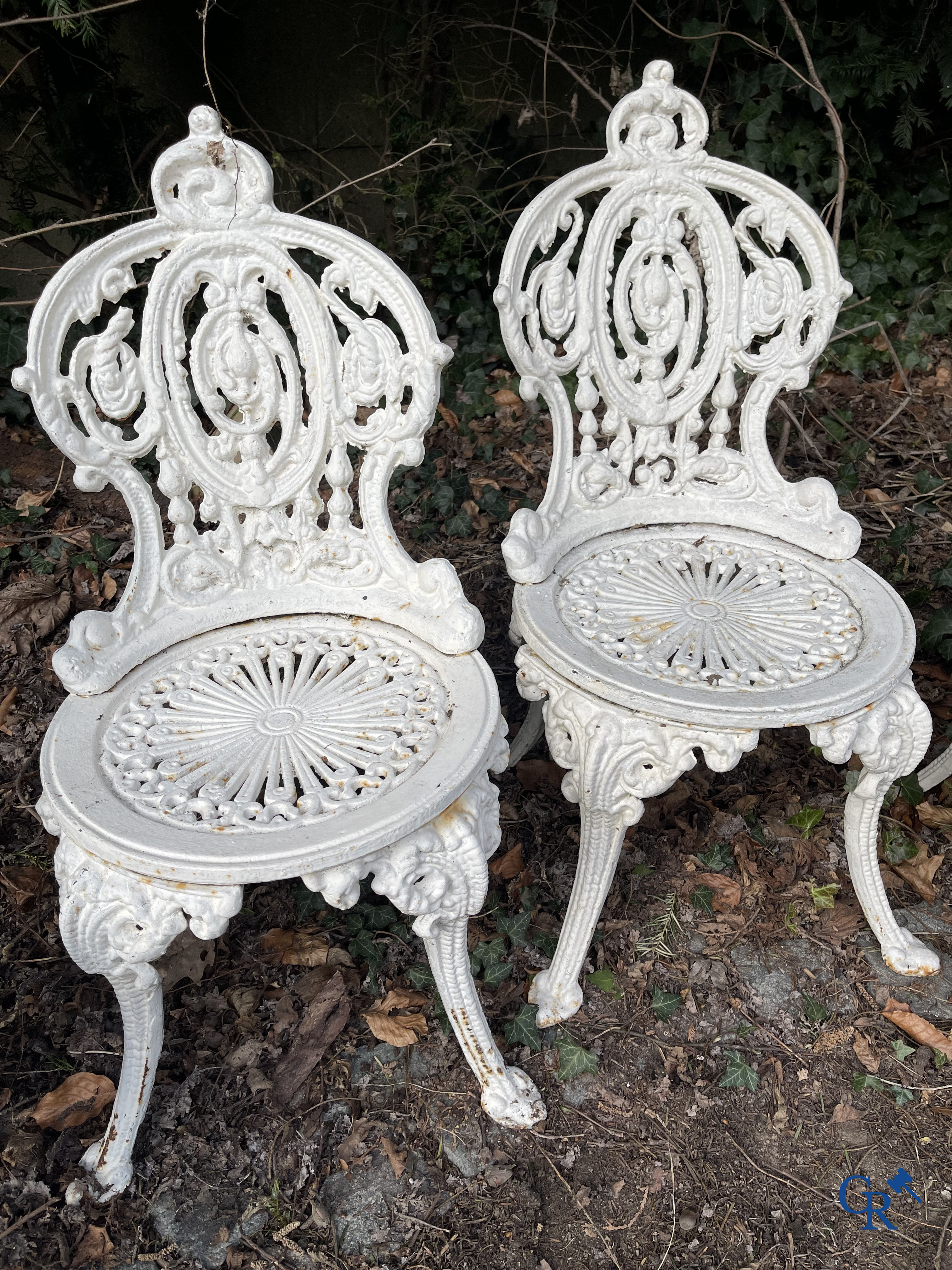 Een reeks van 6 tuinstoelen en 3 geuridons in gietijzer, een metalen tuinbankje bijgevoegd.