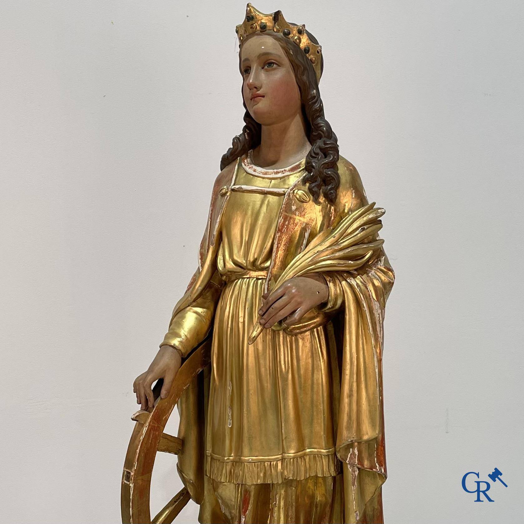 A large gilded and polychrome wooden statue of Saint Catherine of Alexandria.