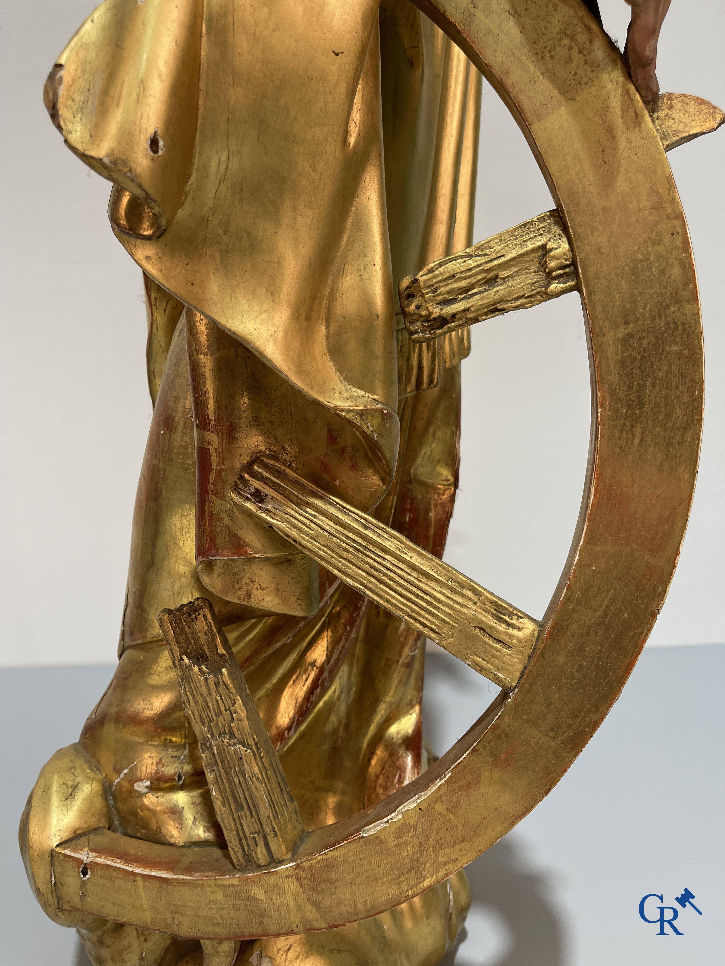 A large gilded and polychrome wooden statue of Saint Catherine of Alexandria.