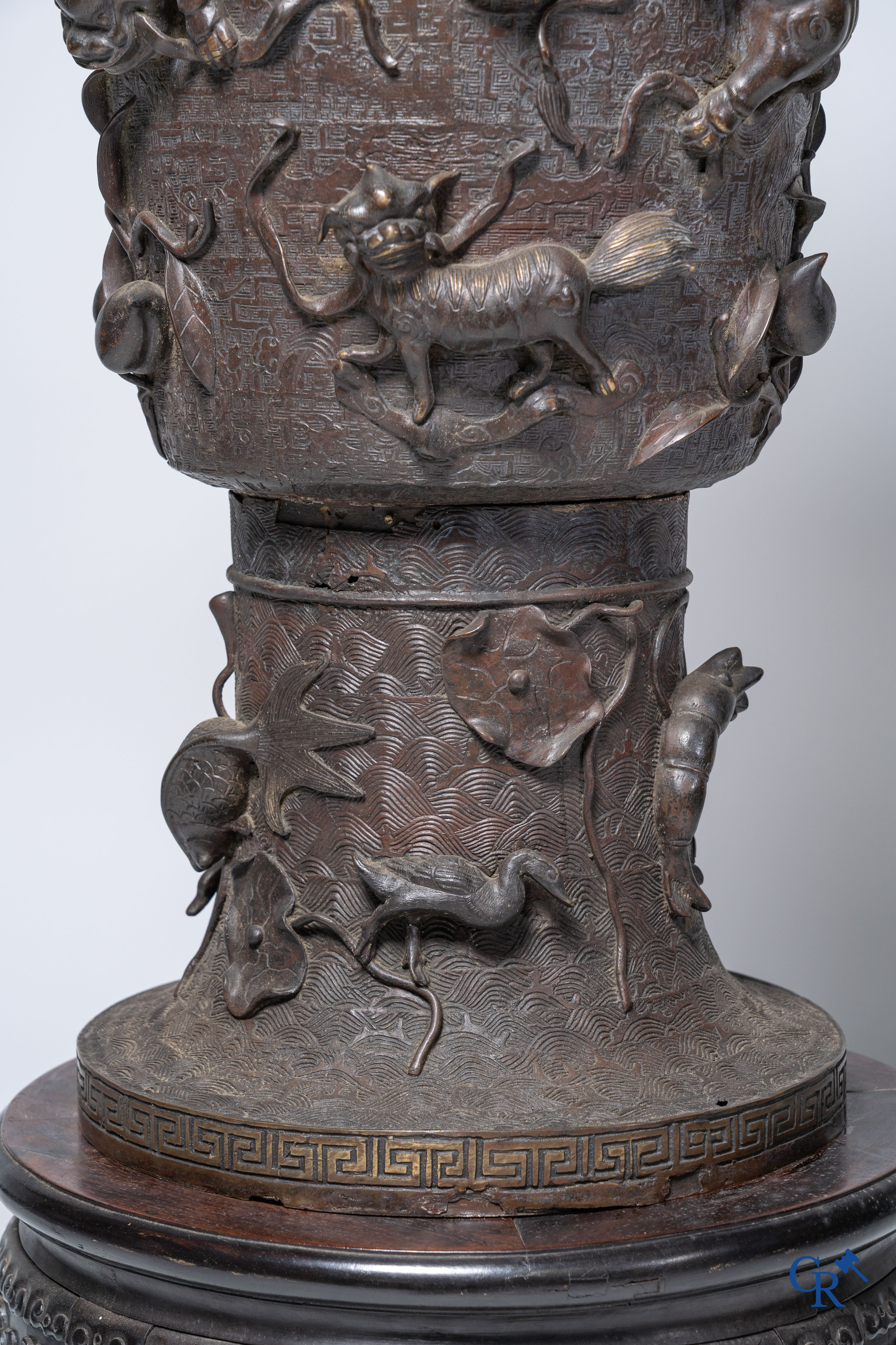 Aziatica, een imposante bronzen Chinese vaas op een sokkel in Chinees hardhout.
