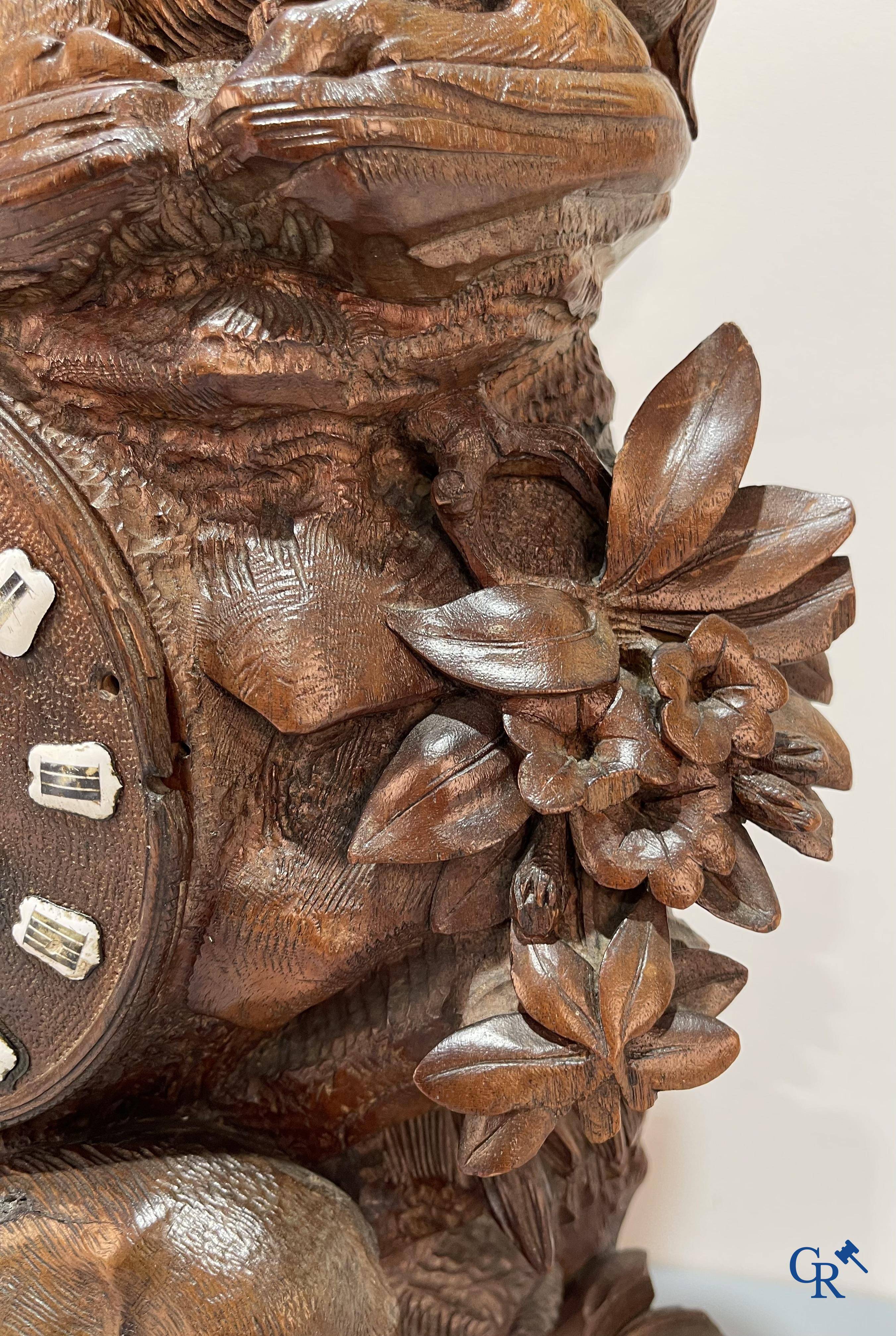 A wood sculpted Black Forest clock with deer in their flora. Germany, late 19th century.