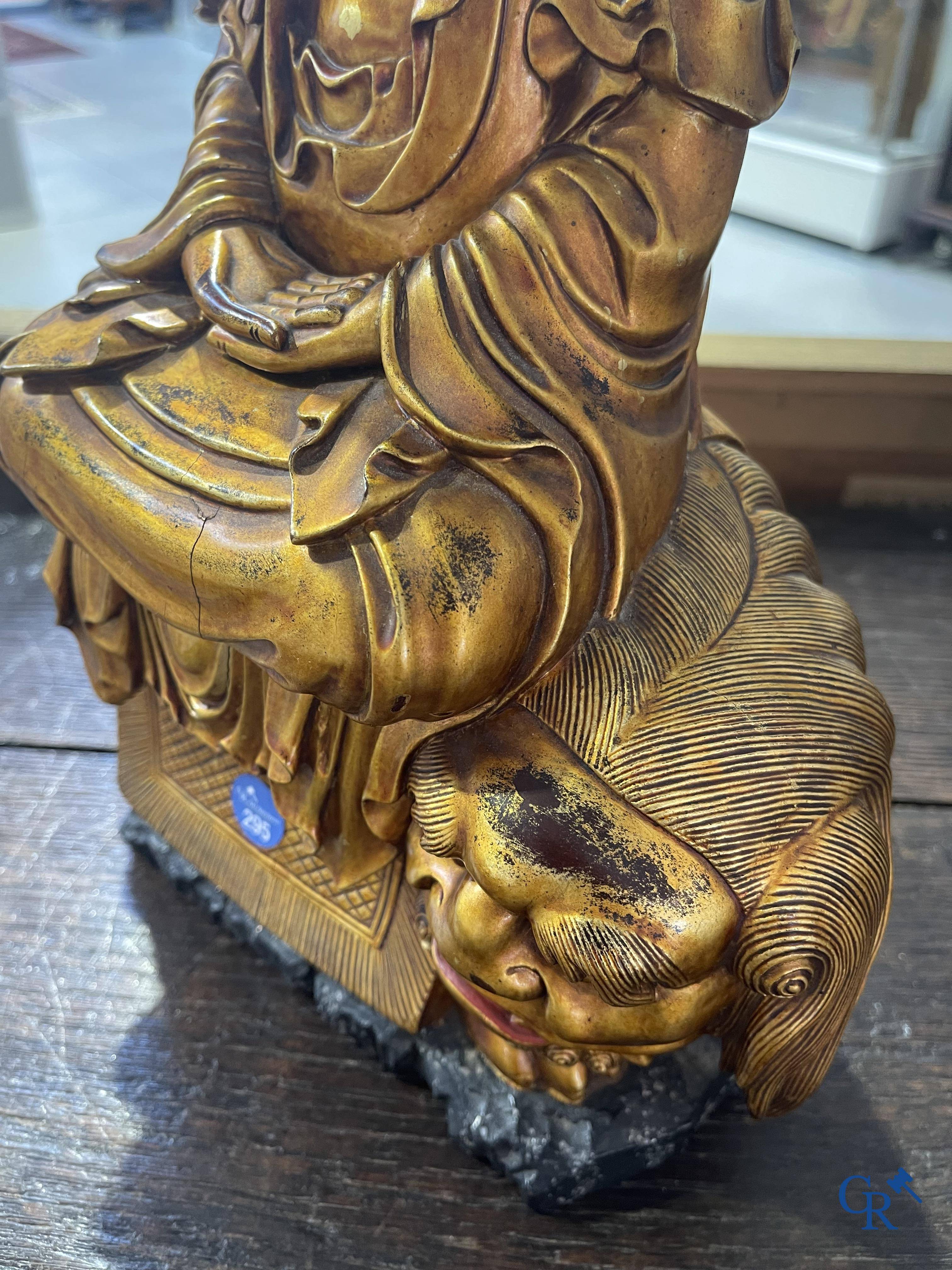 Asian Art: A Chinese sculpture of Vaishravana on a Buddhist lion in lacquered and gilded wood. 19th century.