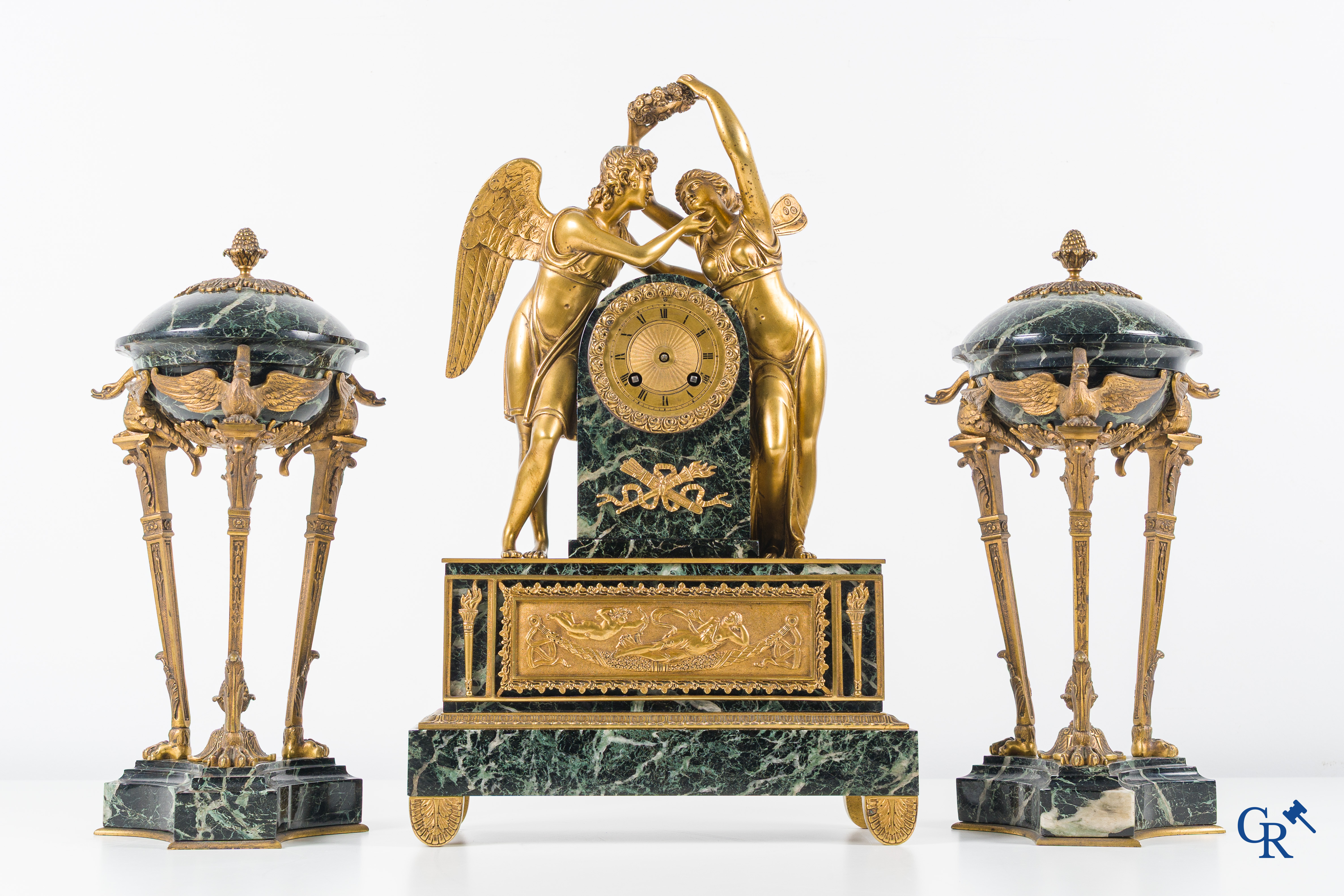 Een 3-delige schouwgarnituur in groen geaderde marmer en vergulde brons. Empire stijl. Circa 1900.