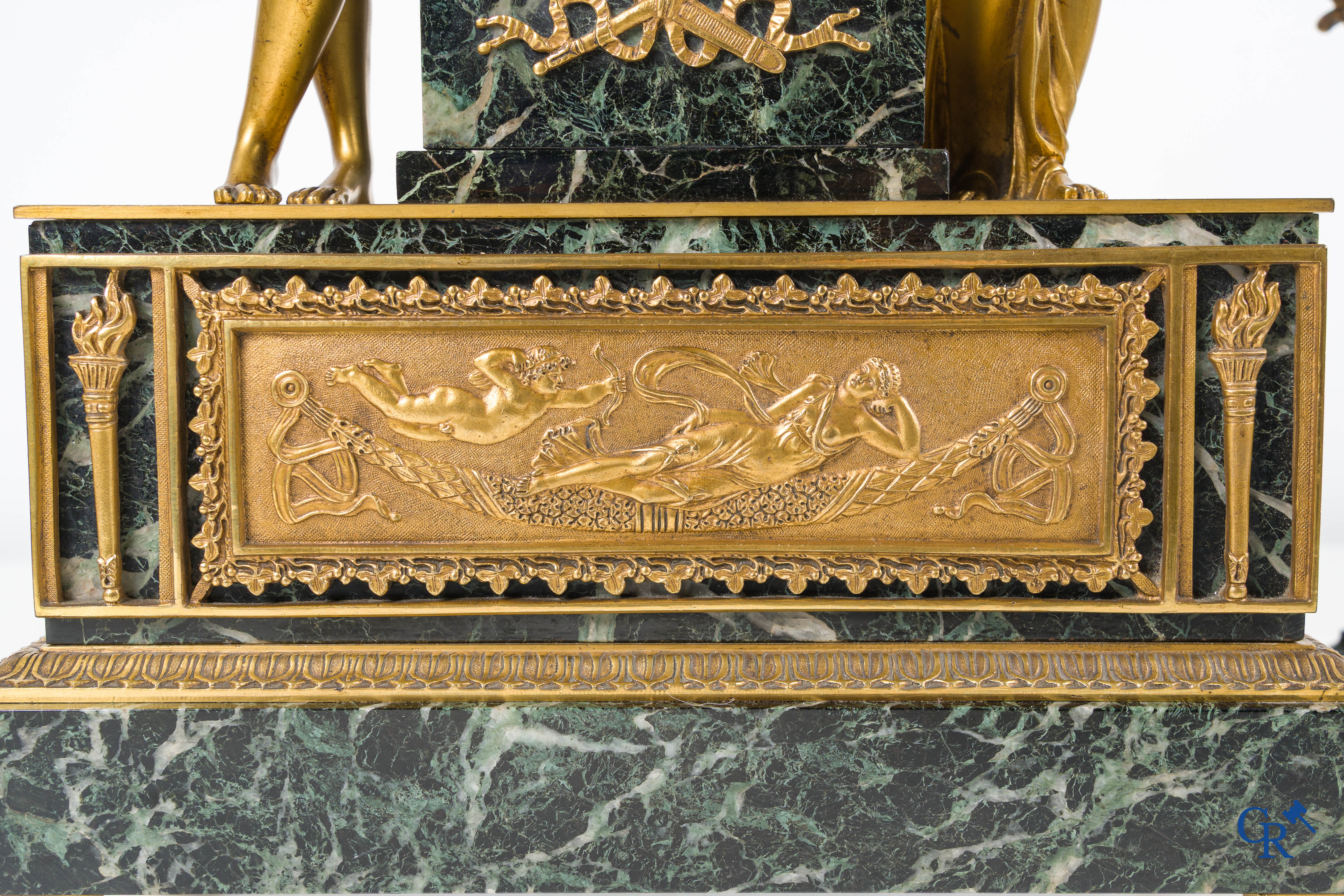 Een 3-delige schouwgarnituur in groen geaderde marmer en vergulde brons. Empire stijl. Circa 1900.