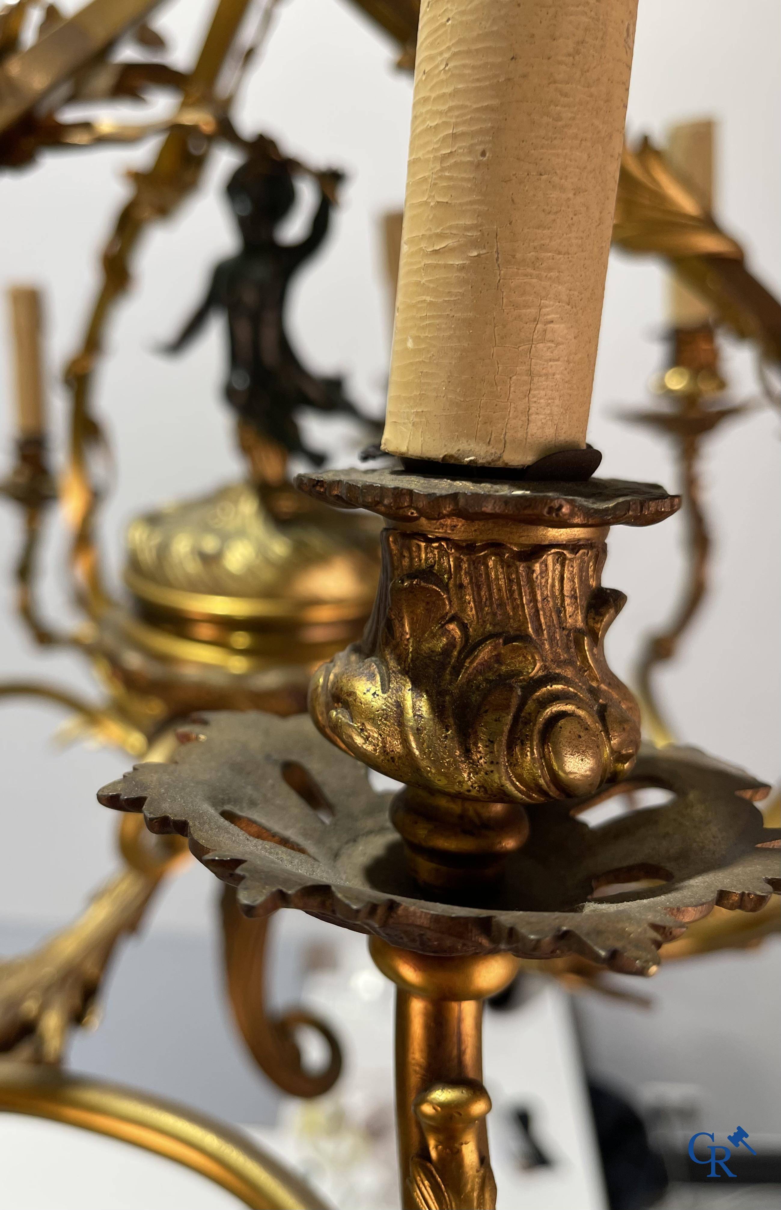 A bronze chandelier with putti and 9 light points in LXV style. Circa 1920.