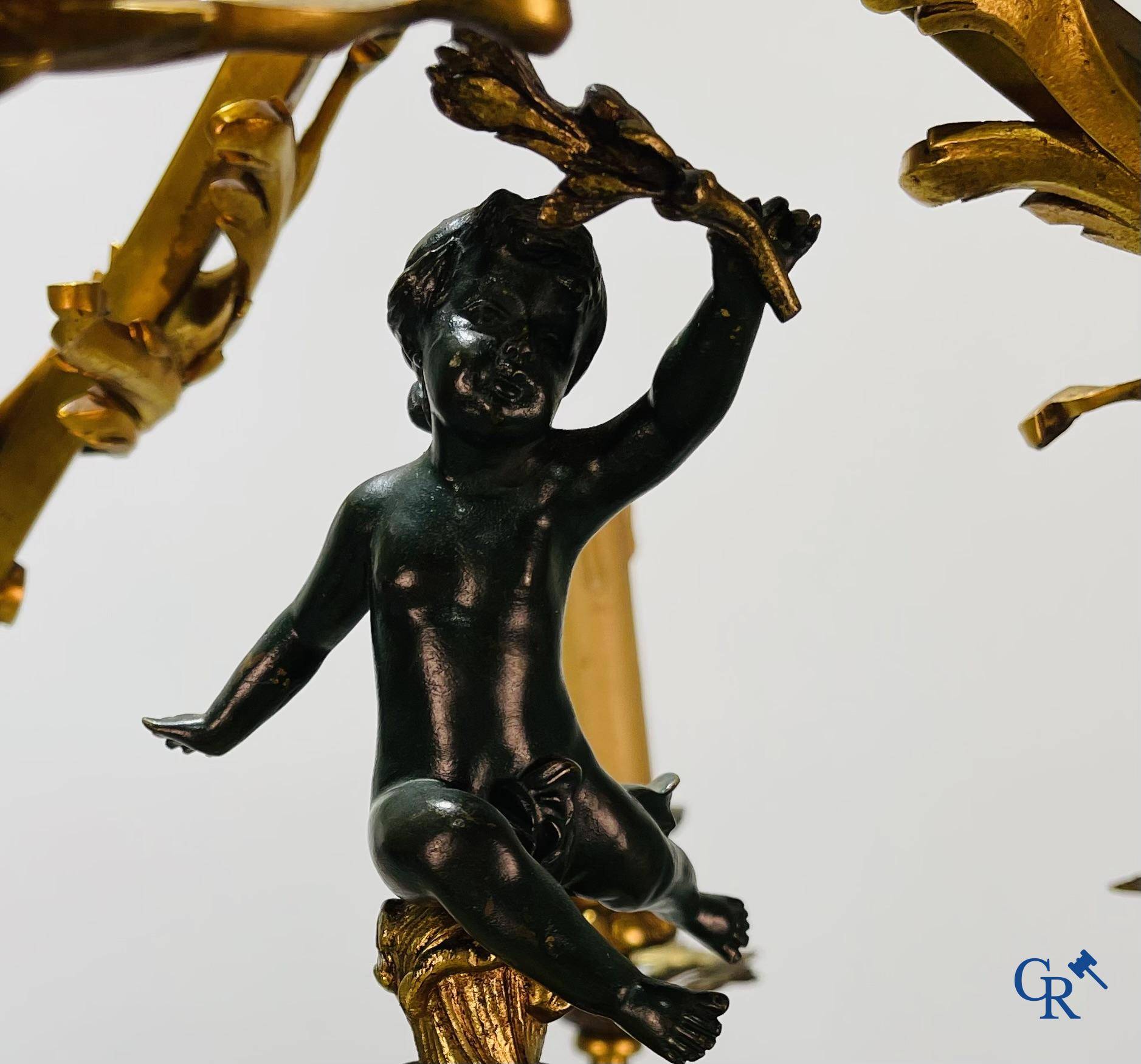 A bronze chandelier with putti and 9 light points in LXV style. Circa 1920.