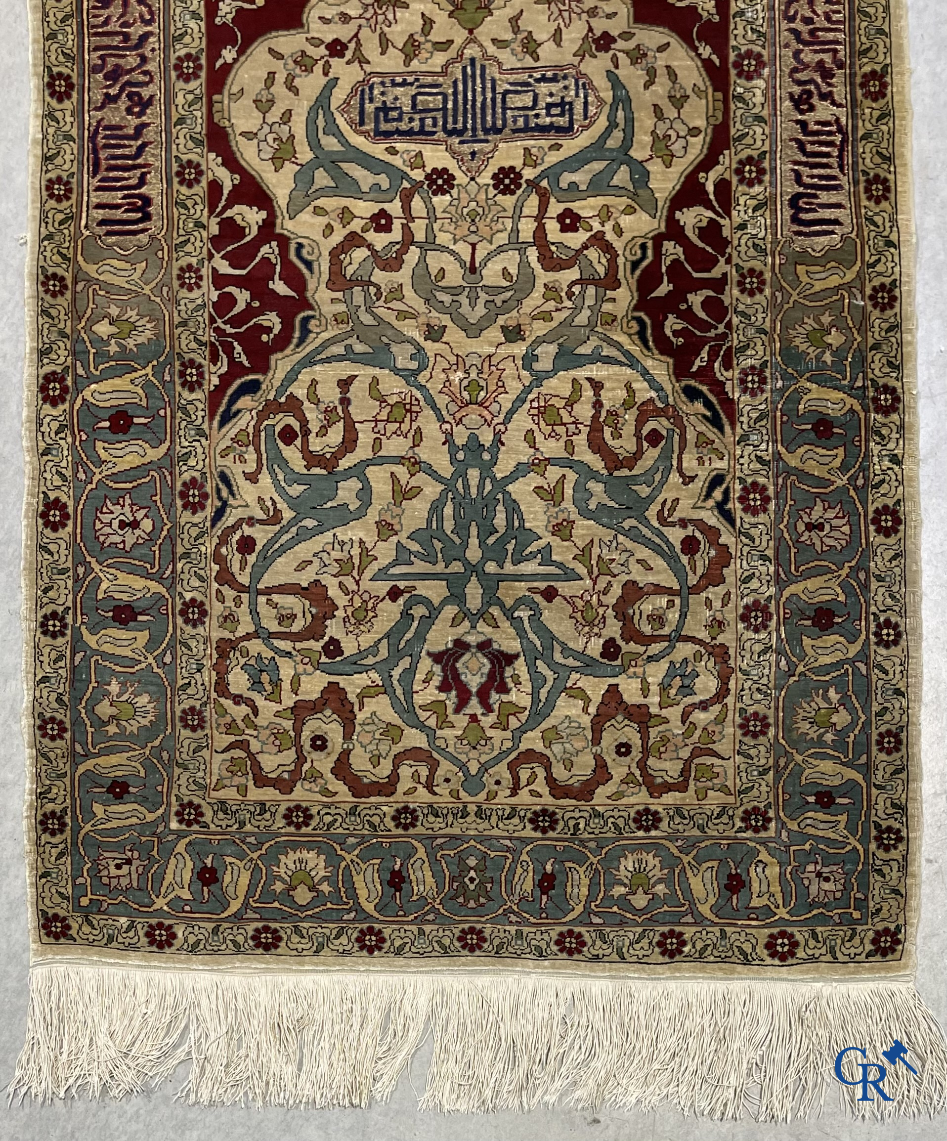 Oosterse tapijten. Een zijden gesigneerd tapijtje met inscripties en bewerkt met gouddraad.