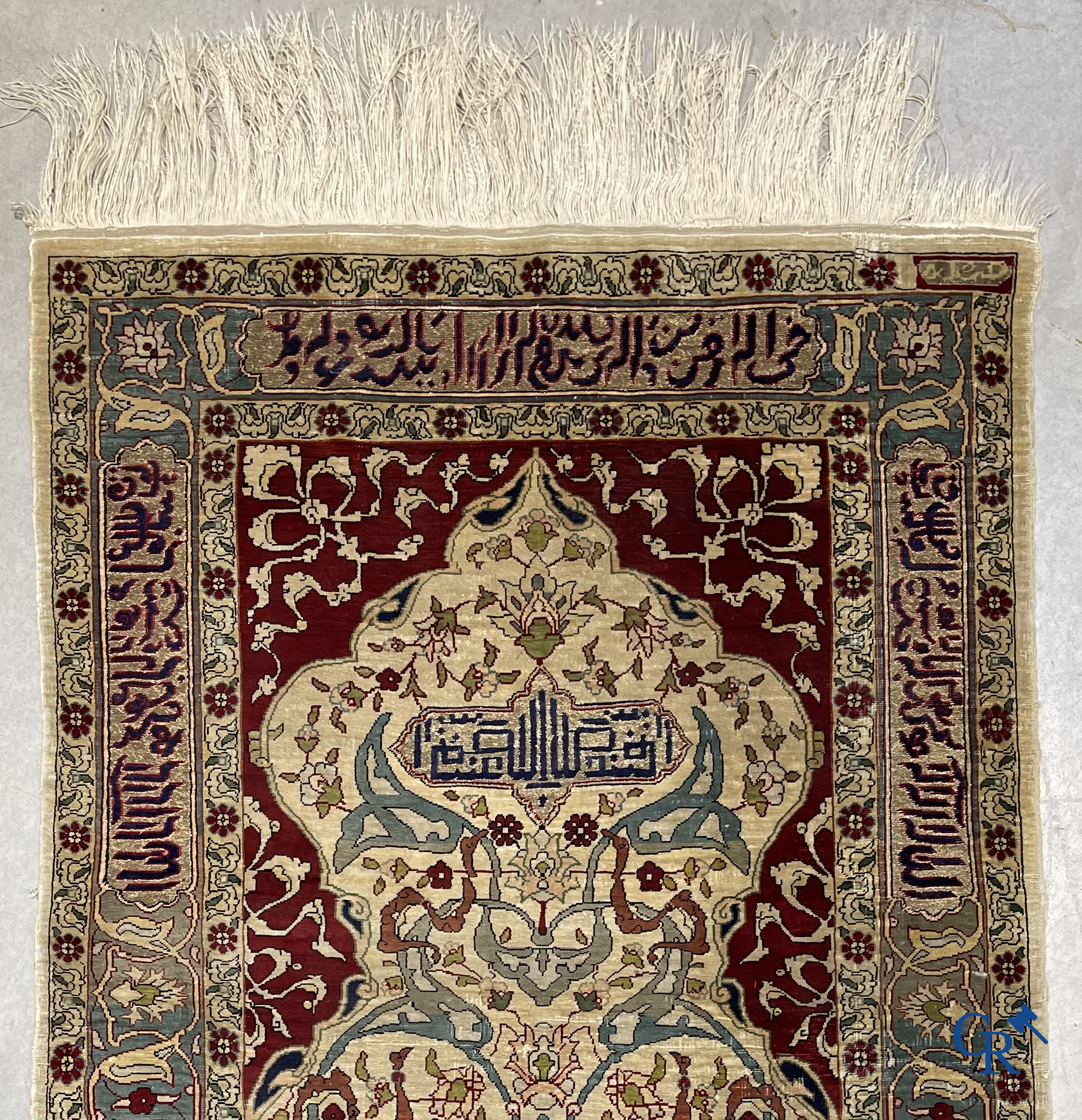 Oosterse tapijten. Een zijden gesigneerd tapijtje met inscripties en bewerkt met gouddraad.