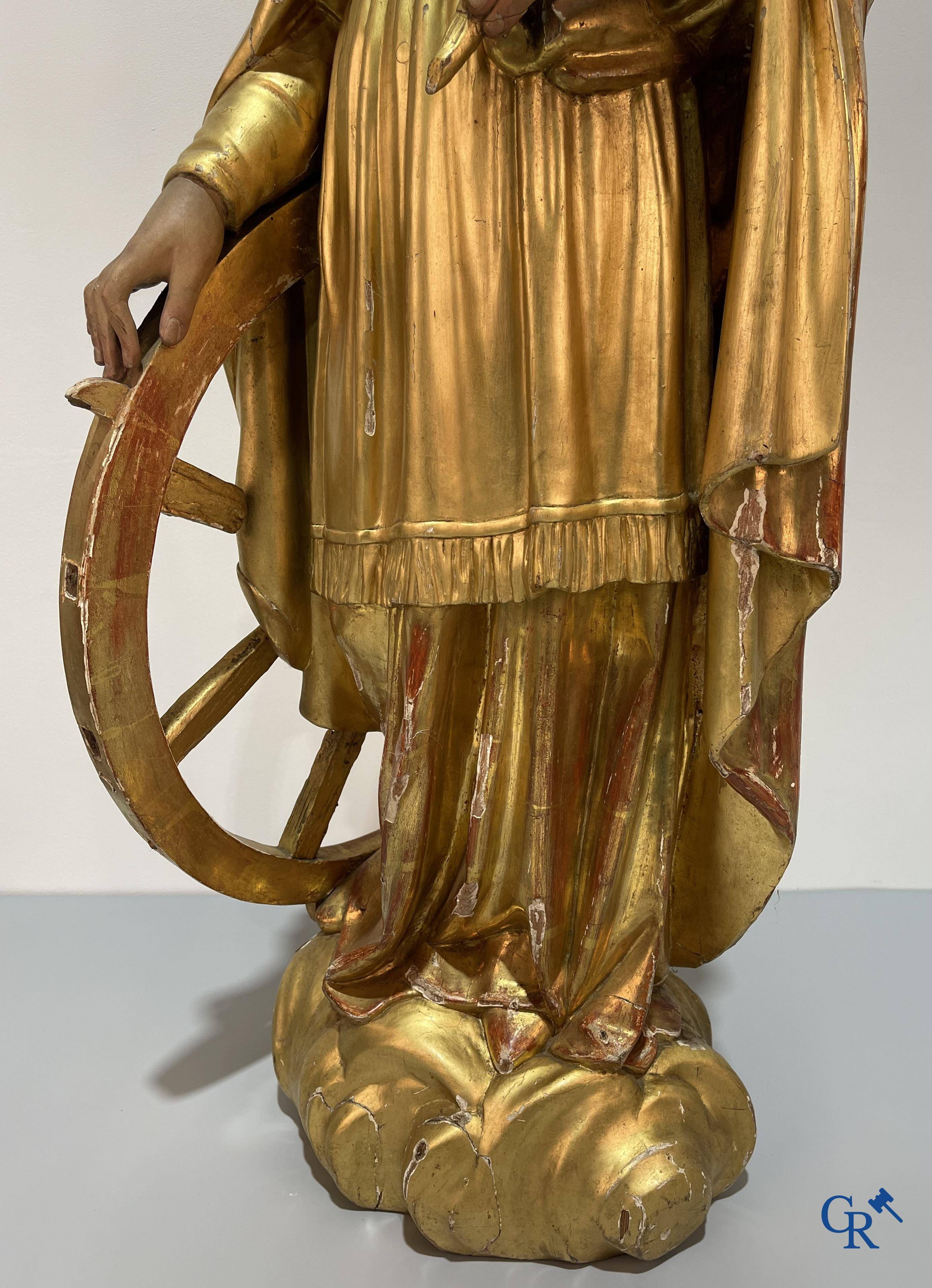 A large gilded and polychrome wooden statue of Saint Catherine of Alexandria.