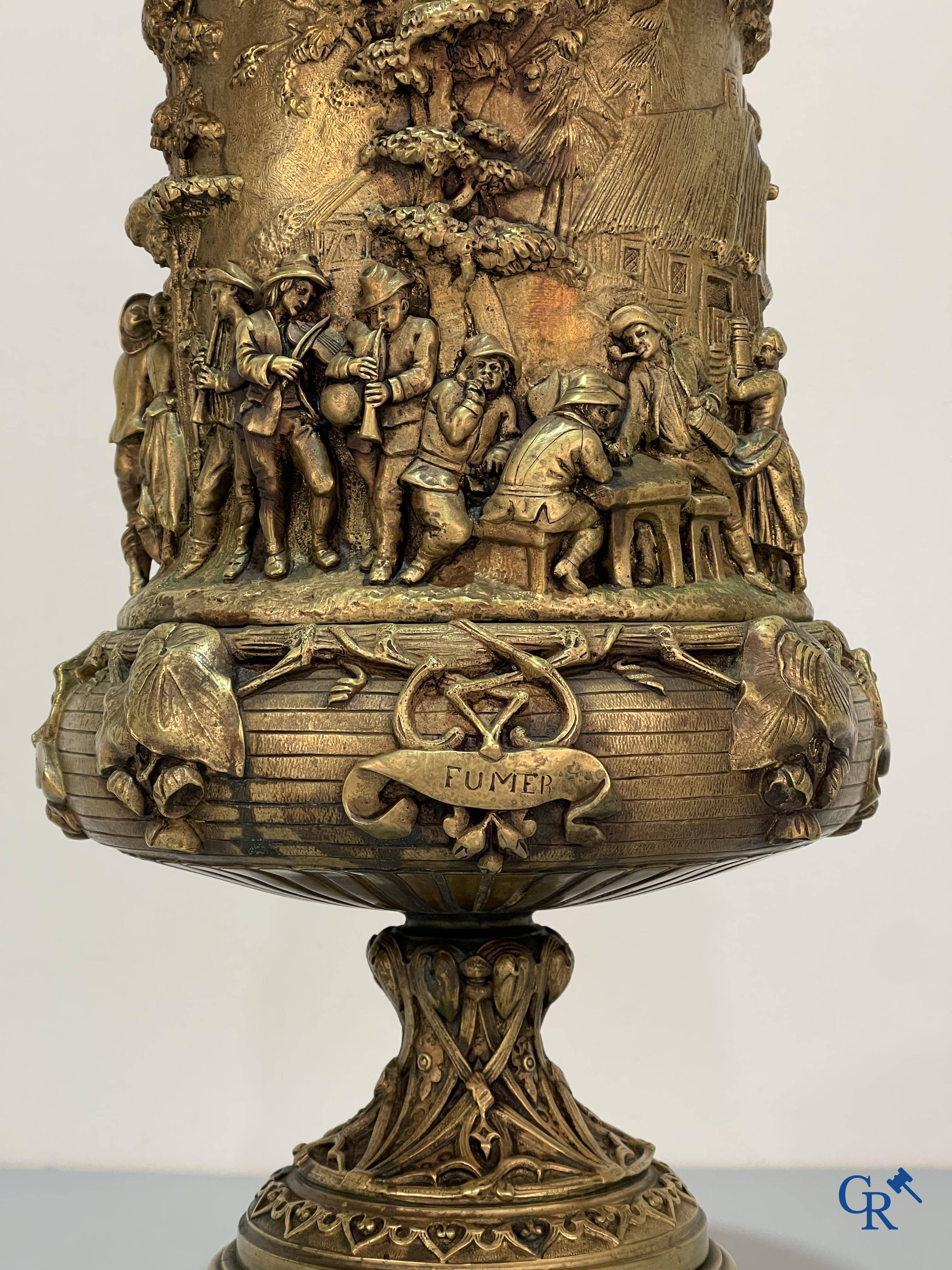 Un imposant pot à tabac en bronze finement travaillée avec les inscriptions "aimer, danser, fumer, boire".<br />
19ème siècle.