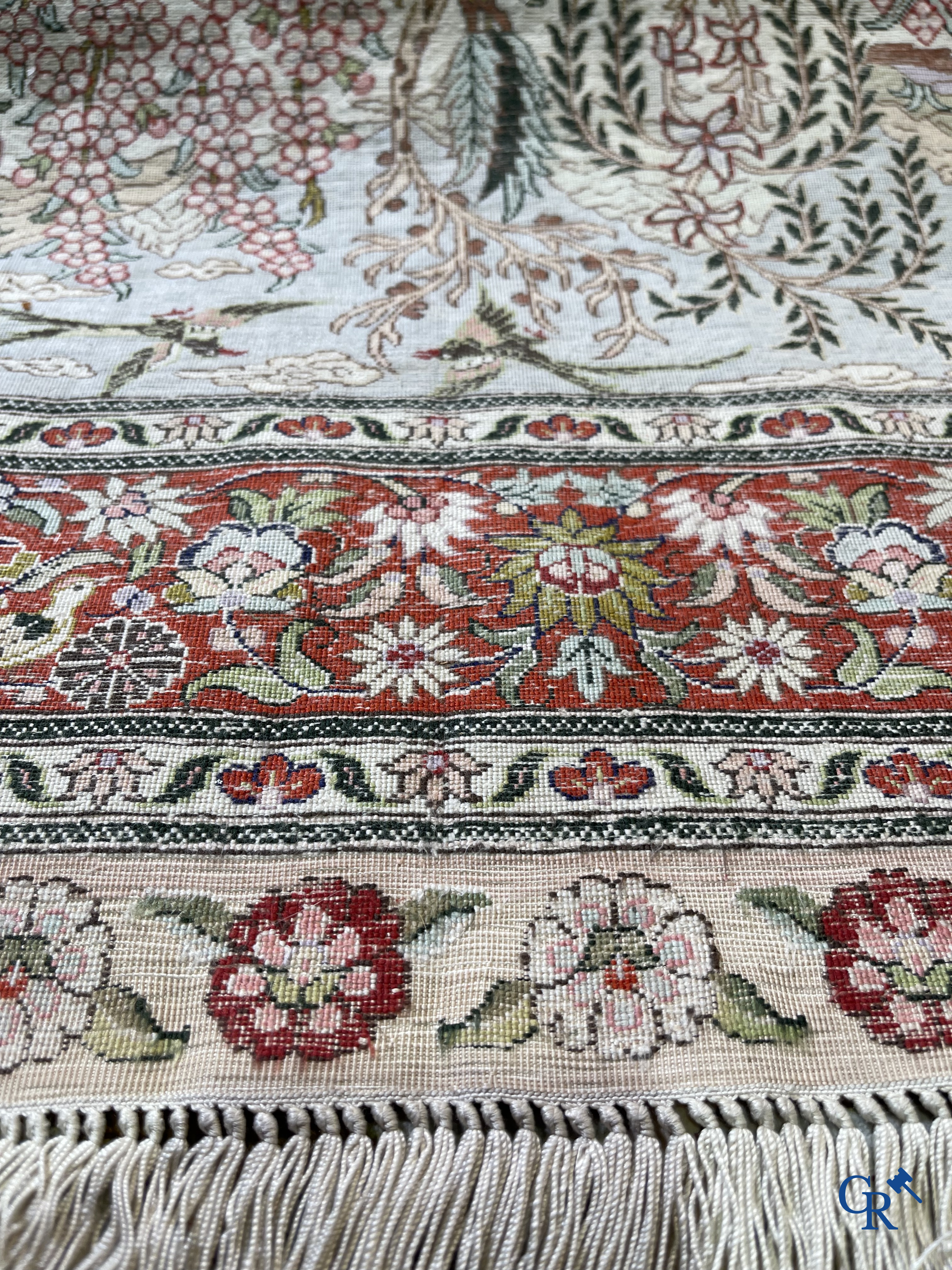 Tapis d'Orient: Un tapis en soie finement noué à la main avec des oiseaux aquatiques dans un paysage sur fond floral.