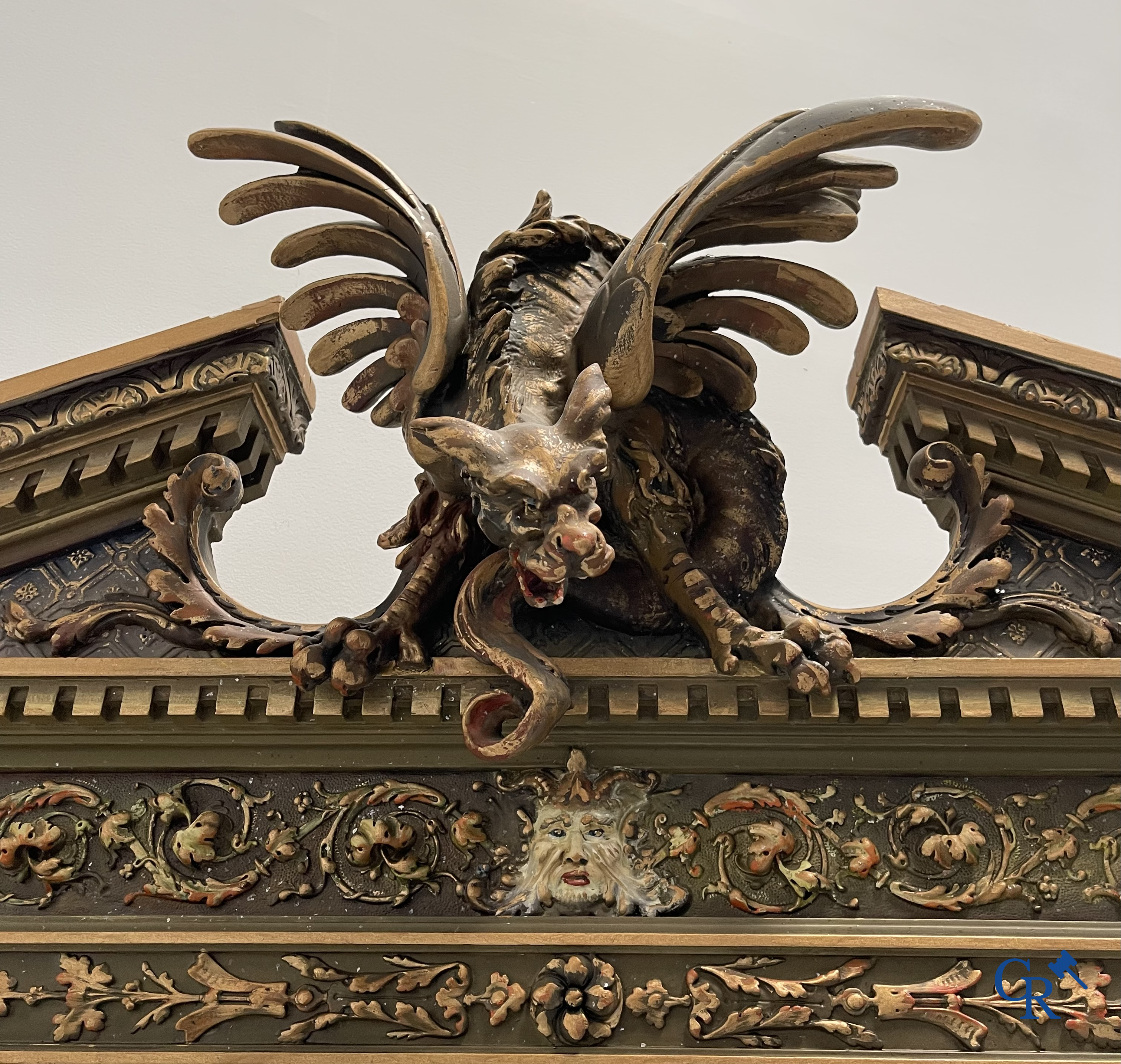 A large patinated fireplace mirror with a dragon. Around 1900.