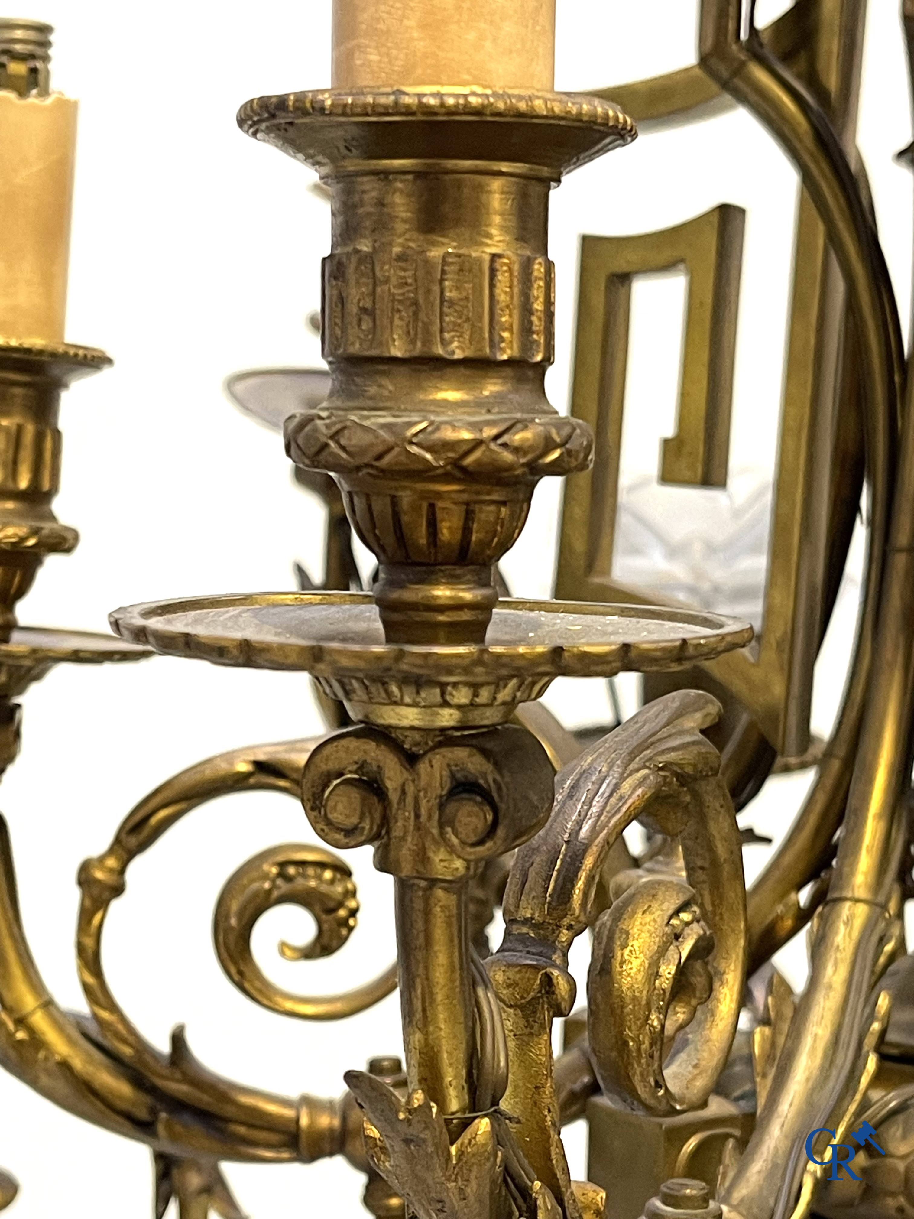 A lot of an imposing chandelier with 12 light points, a lamp belge with bronze frame and a fireplace piece.