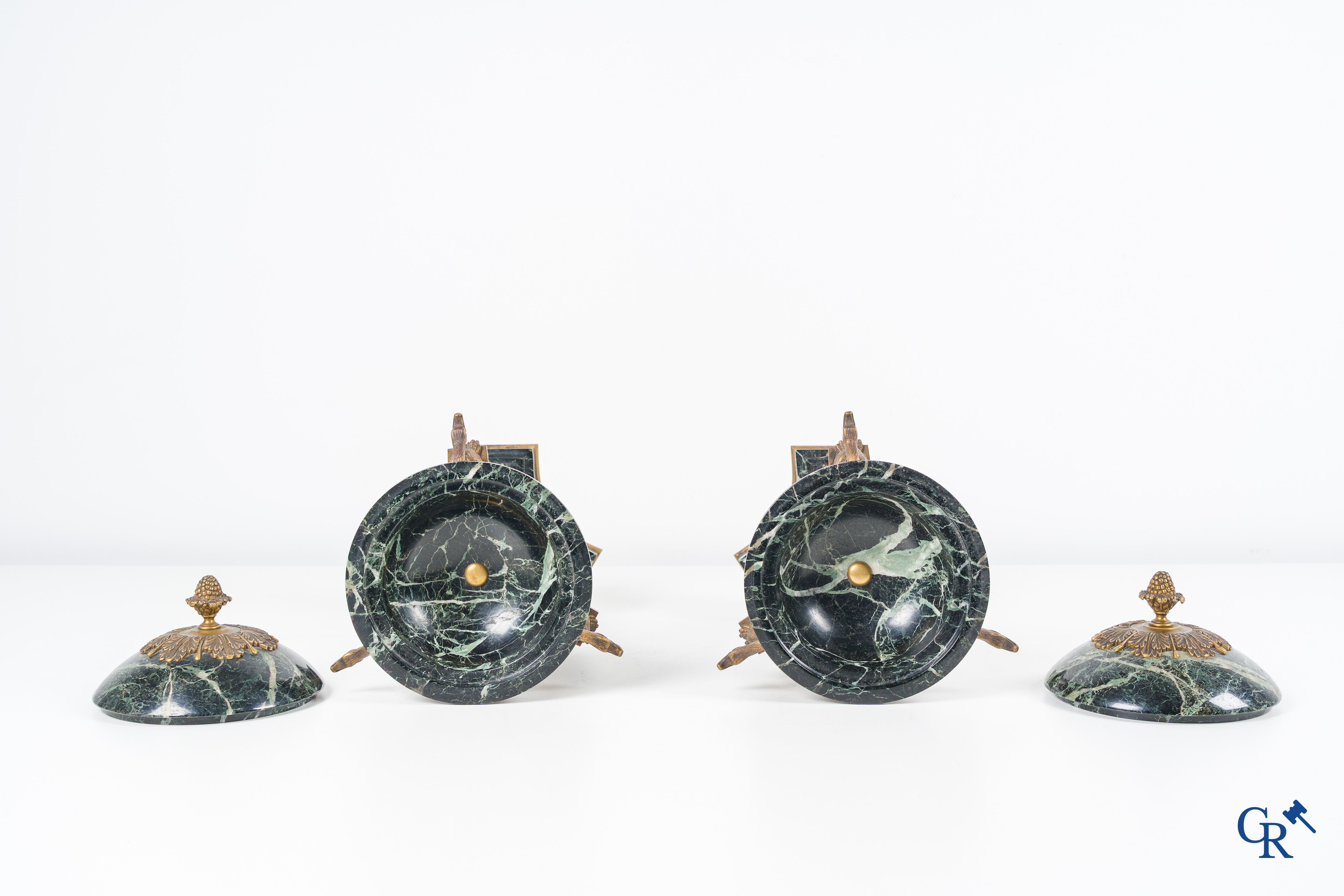 Een 3-delige schouwgarnituur in groen geaderde marmer en vergulde brons. Empire stijl. Circa 1900.