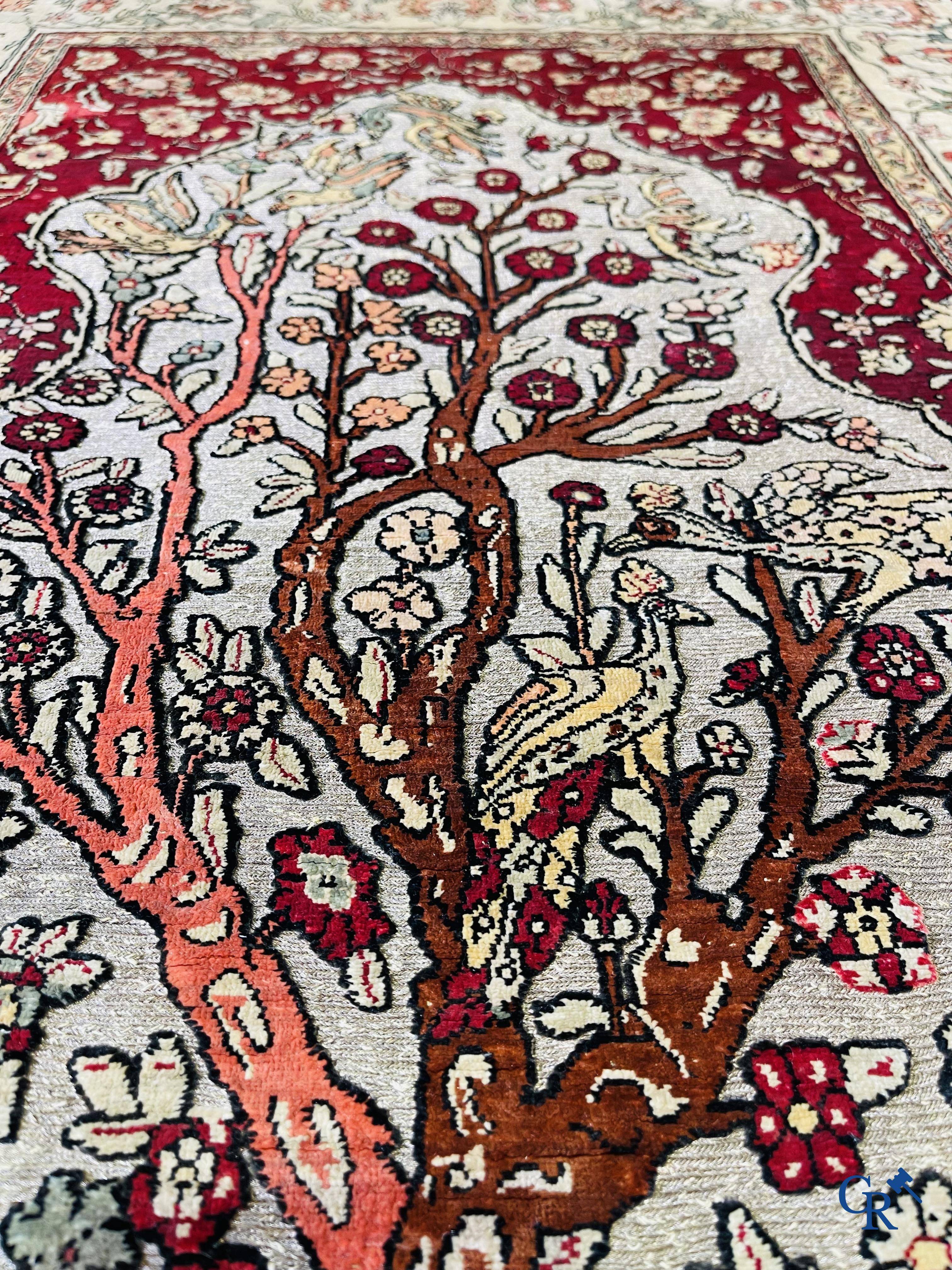 Oriental carpets, a hand-knotted carpet in silk with forest animals in a floral decor on a background in gold thread.