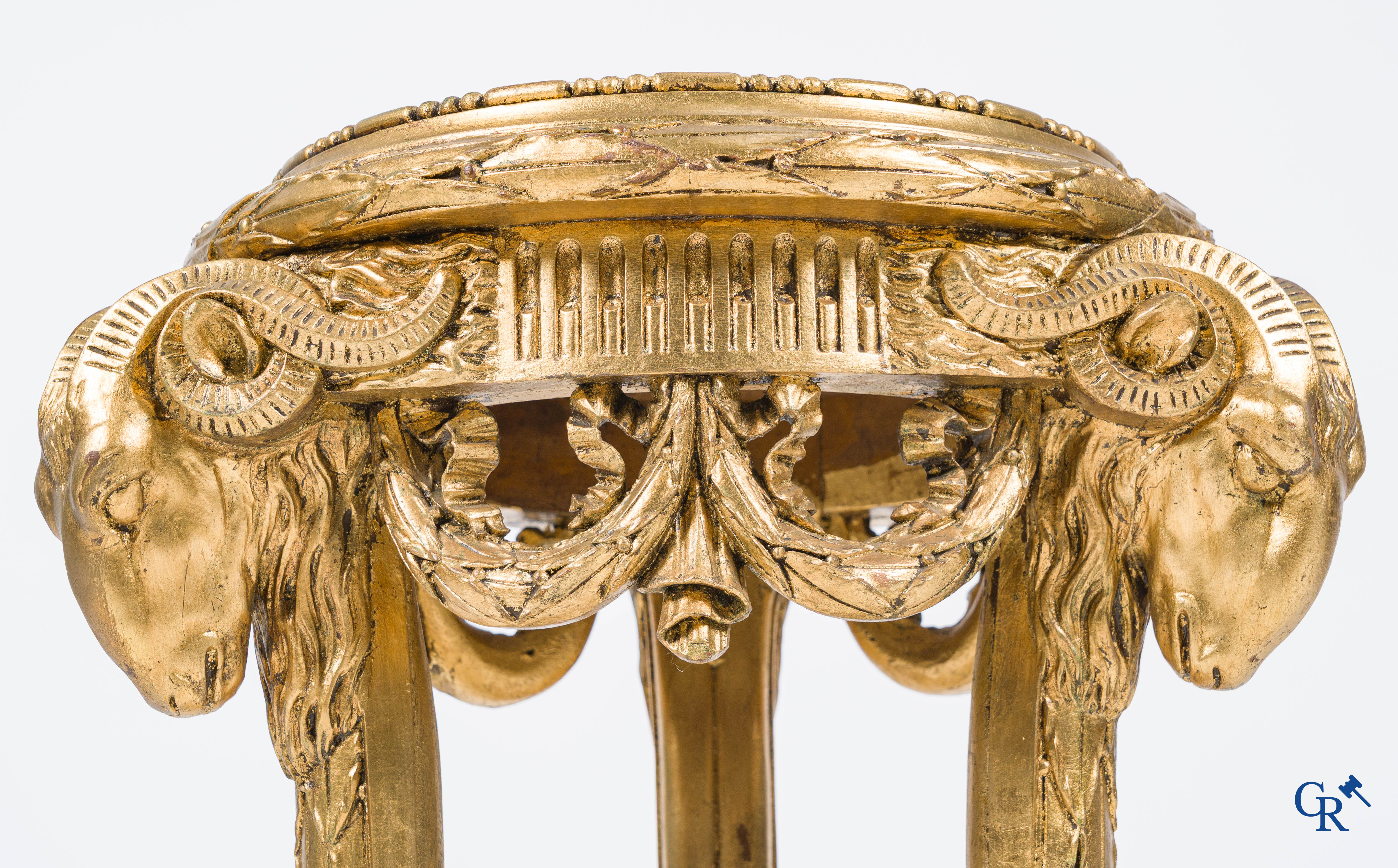 A large wood carved and gilded plinth with ram heads and garlands. LXVI style, circa 1900.