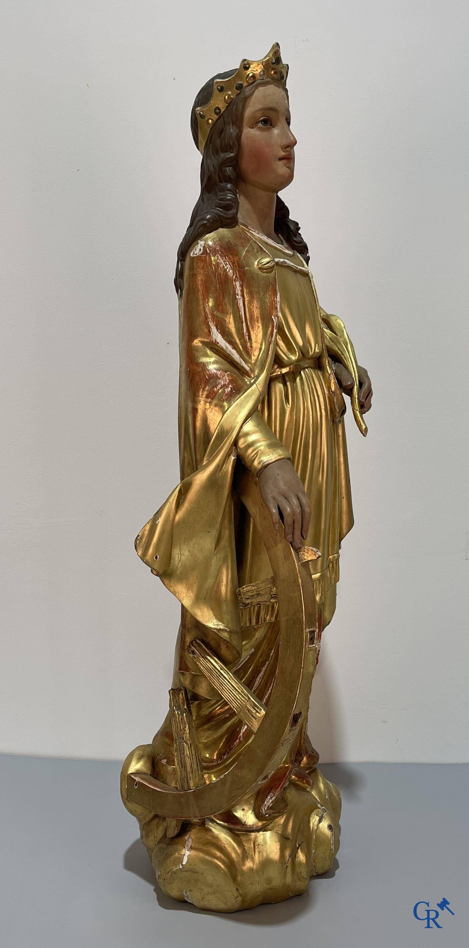 A large gilded and polychrome wooden statue of Saint Catherine of Alexandria.