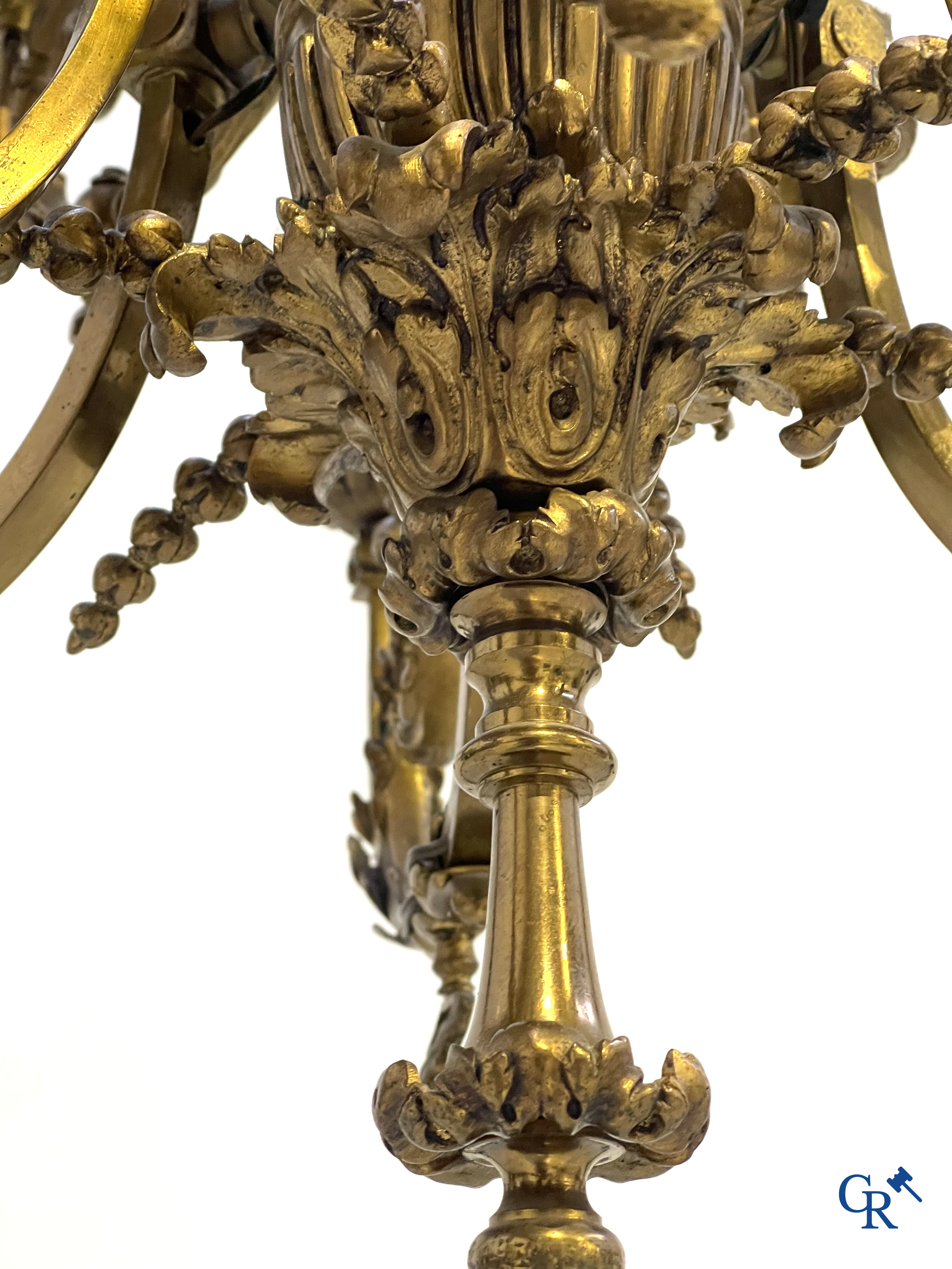 A lot of an imposing chandelier with 12 light points, a lamp belge with bronze frame and a fireplace piece.