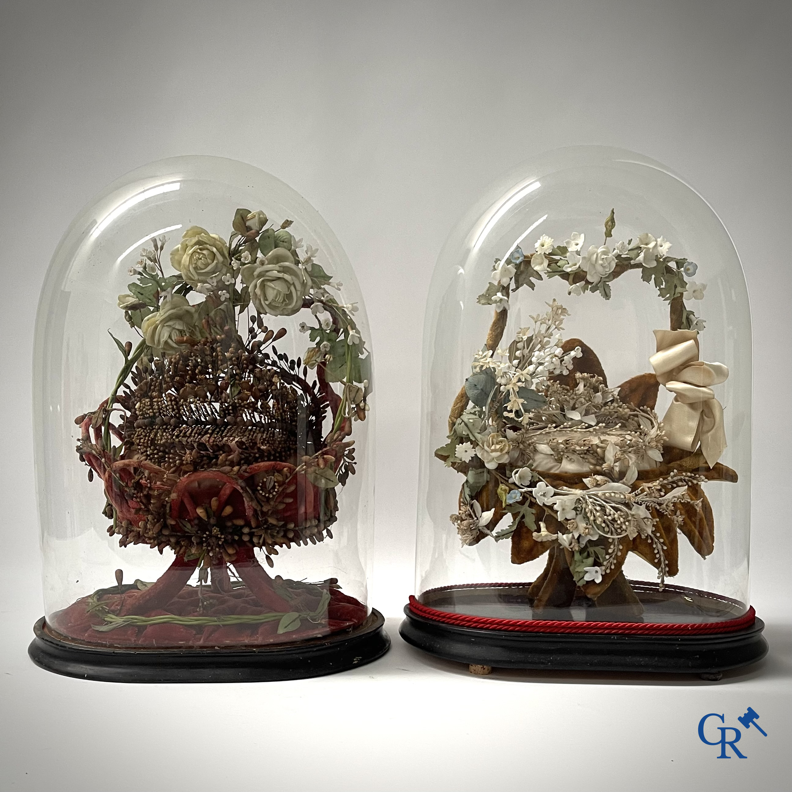 2 globes en verre avec un bouquet de mariage en forme de panier, décorés de fleurs en porcelaine fine. Vers 1900.