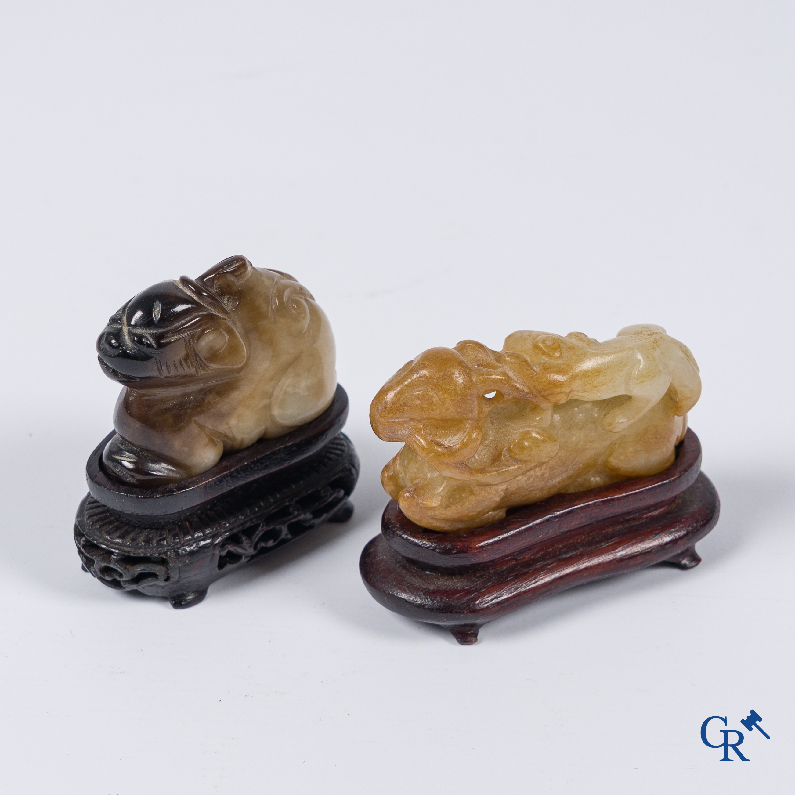 Aziatica. Een bleek celadon en roestbruin kleurige jade hertengroep en een bruinkleurig mythisch beest in jade.