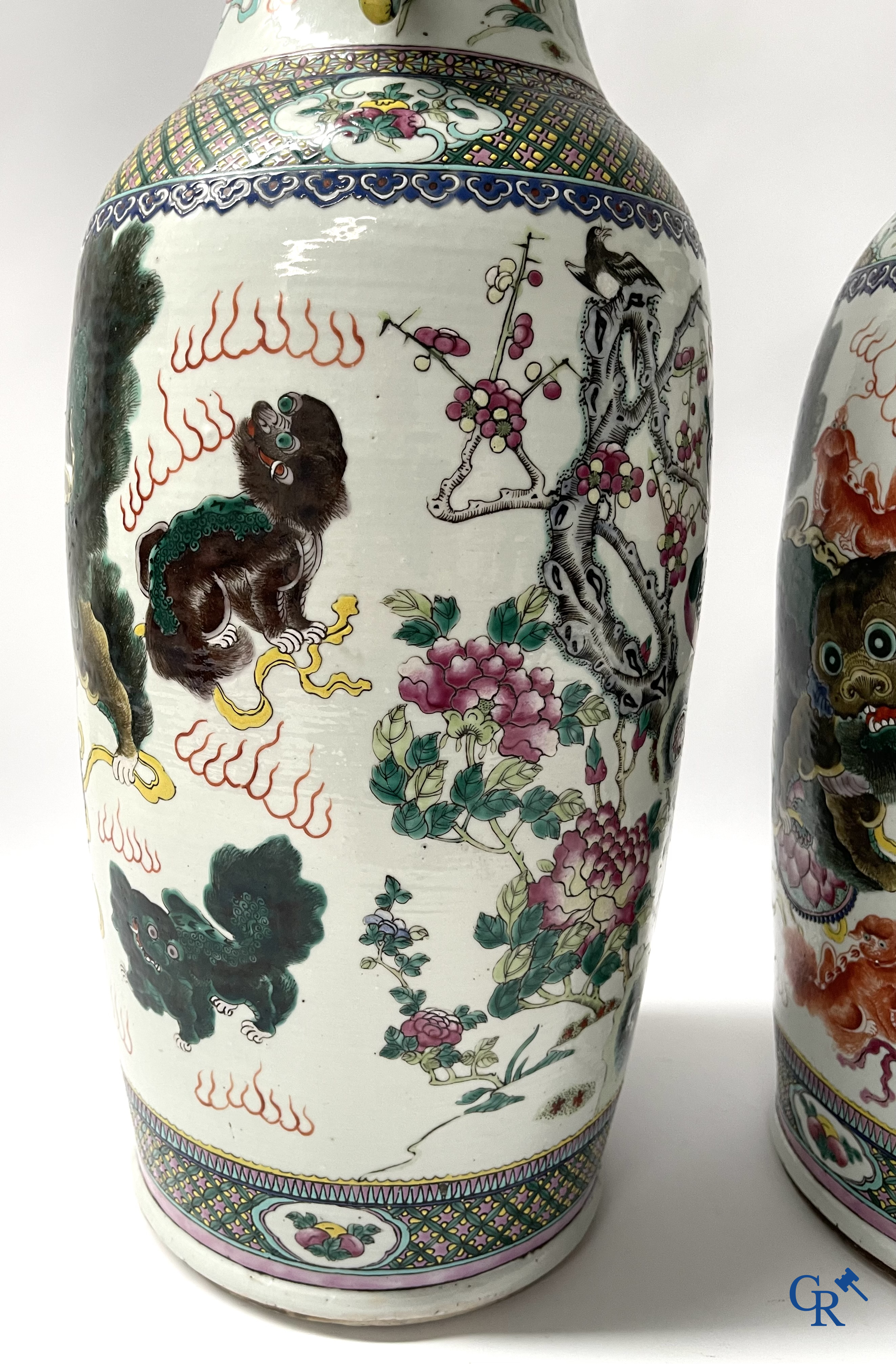 Asian Art, A pair of Chinese famille rose vases with peacocks and Fo dogs. 19th century.