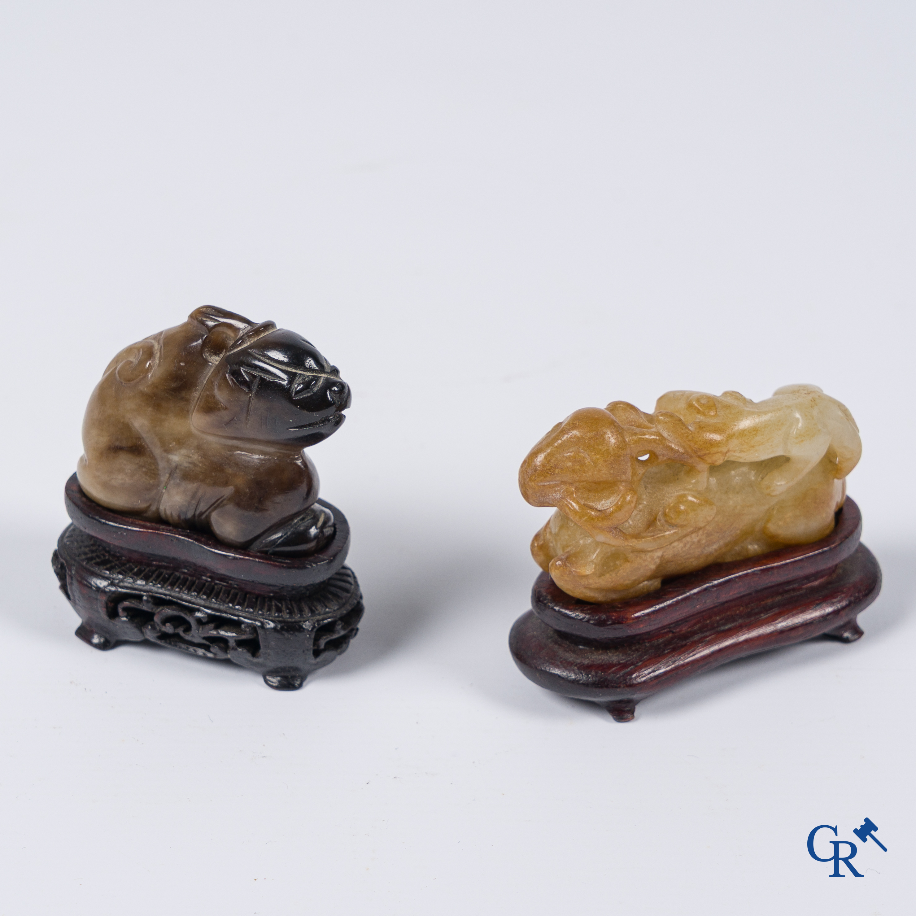 Aziatica. Een bleek celadon en roestbruin kleurige jade hertengroep en een bruinkleurig mythisch beest in jade.